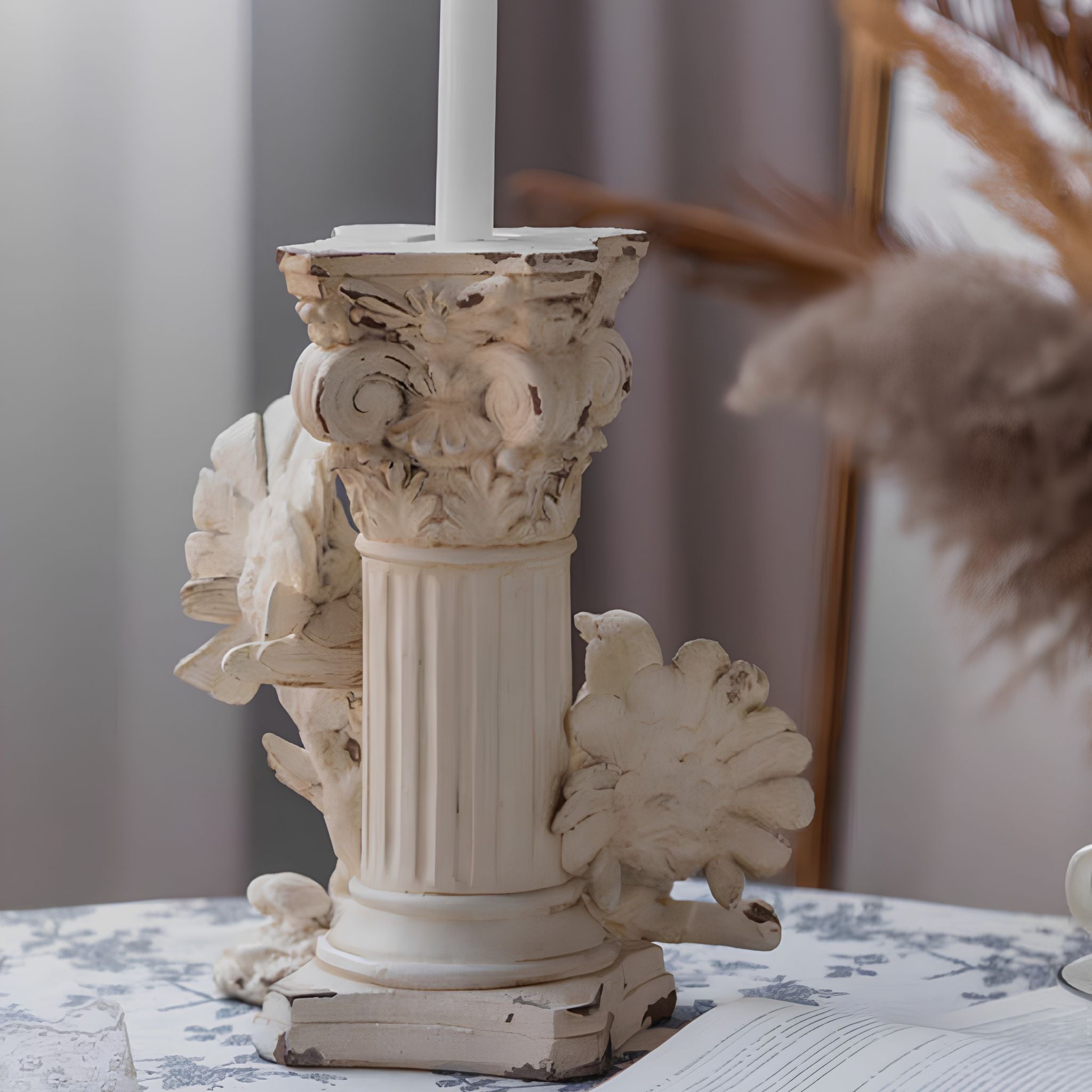 Étienne candle holder showing the recessed top for a taper, carved capital and fluted column with the two doves at the base.