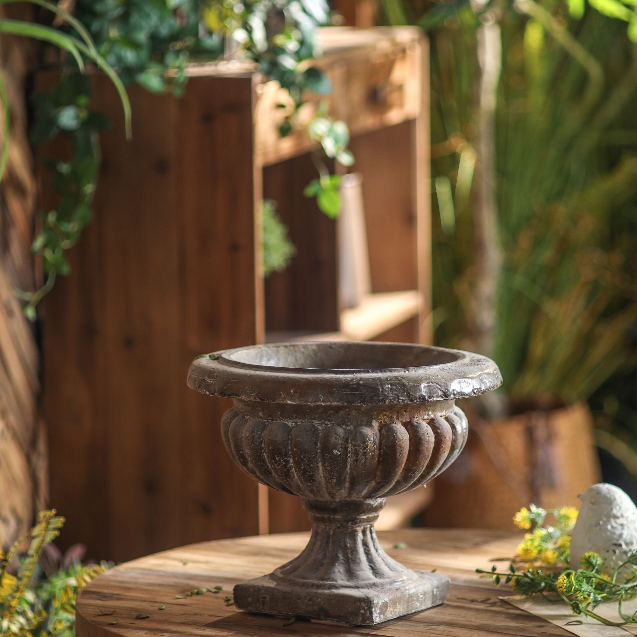 Évangéline urn planter shown empty, dark patina, gadrooned bowl, fluted stem and square plinth.