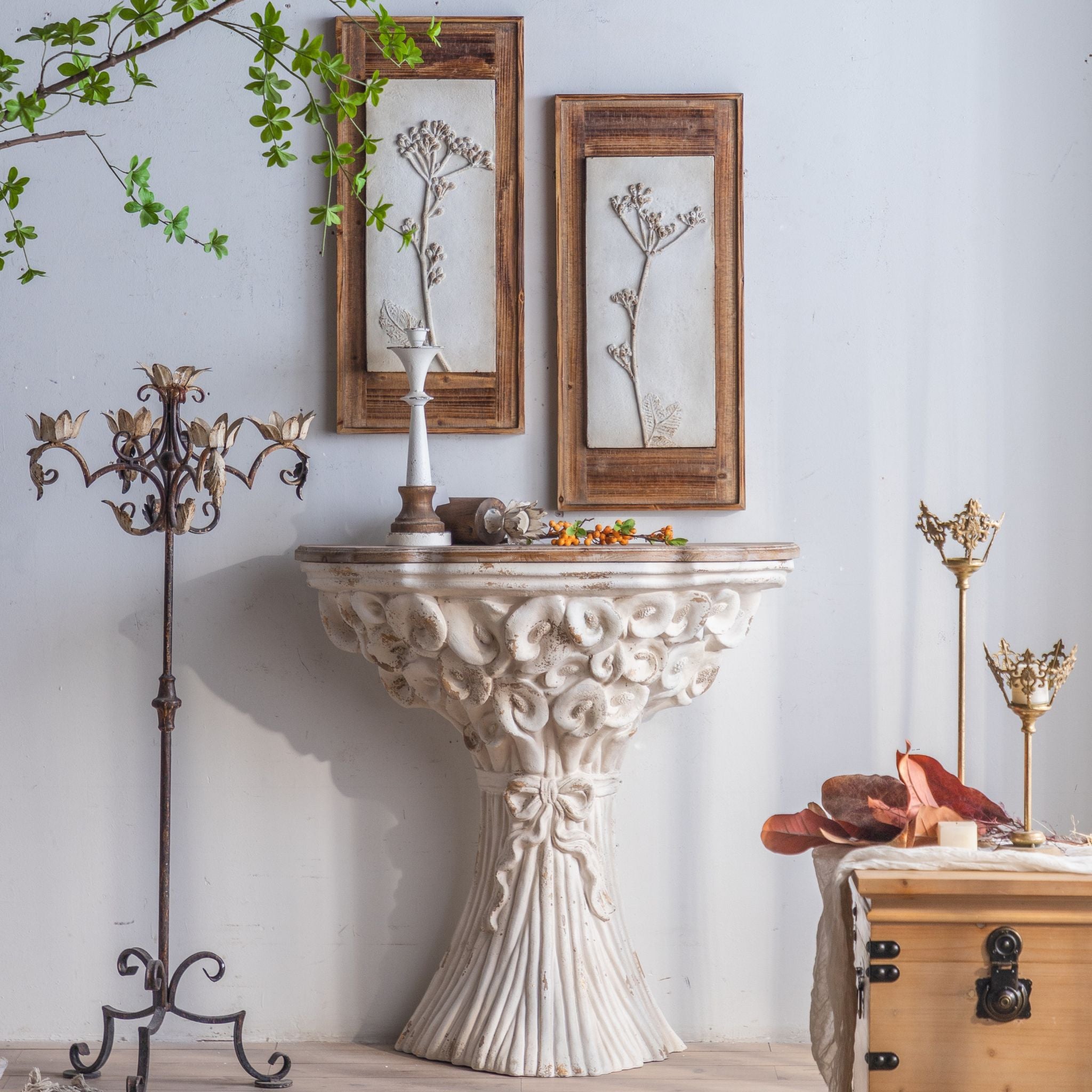 Celestine console mounted on a wall with framed botanical art and a candelabra