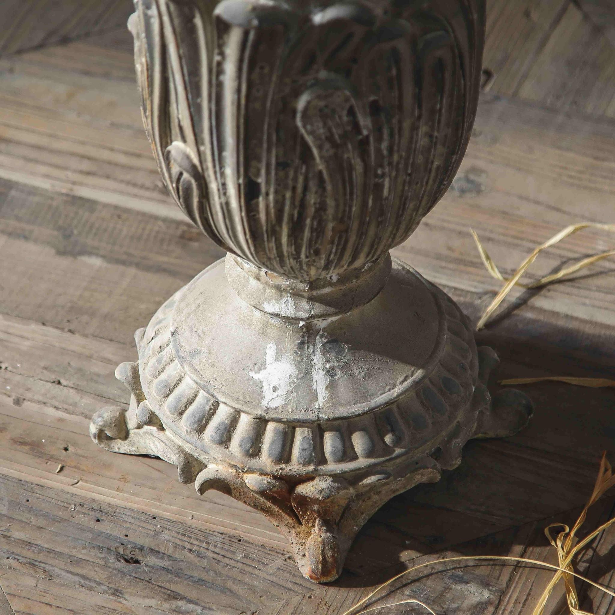 Florent close-up of the acanthus base, turned pedestal and scrolled foot on a timber floor.