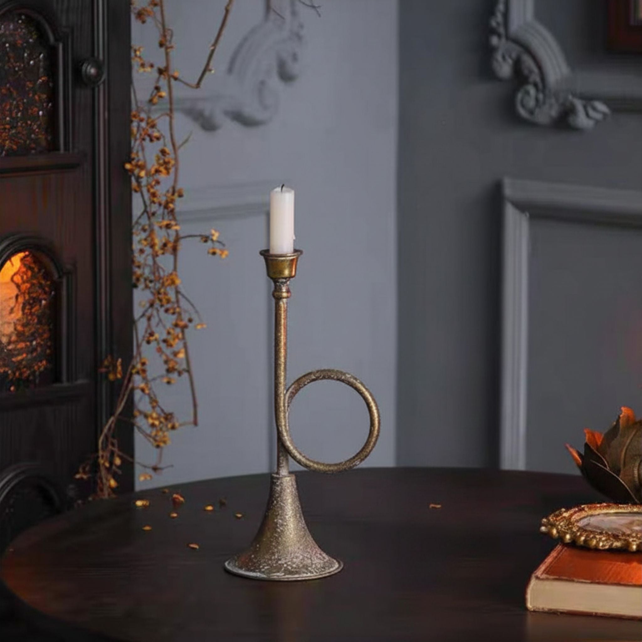 Renée French provincial horn candle holder in antique gold on a dark table, styled scene.