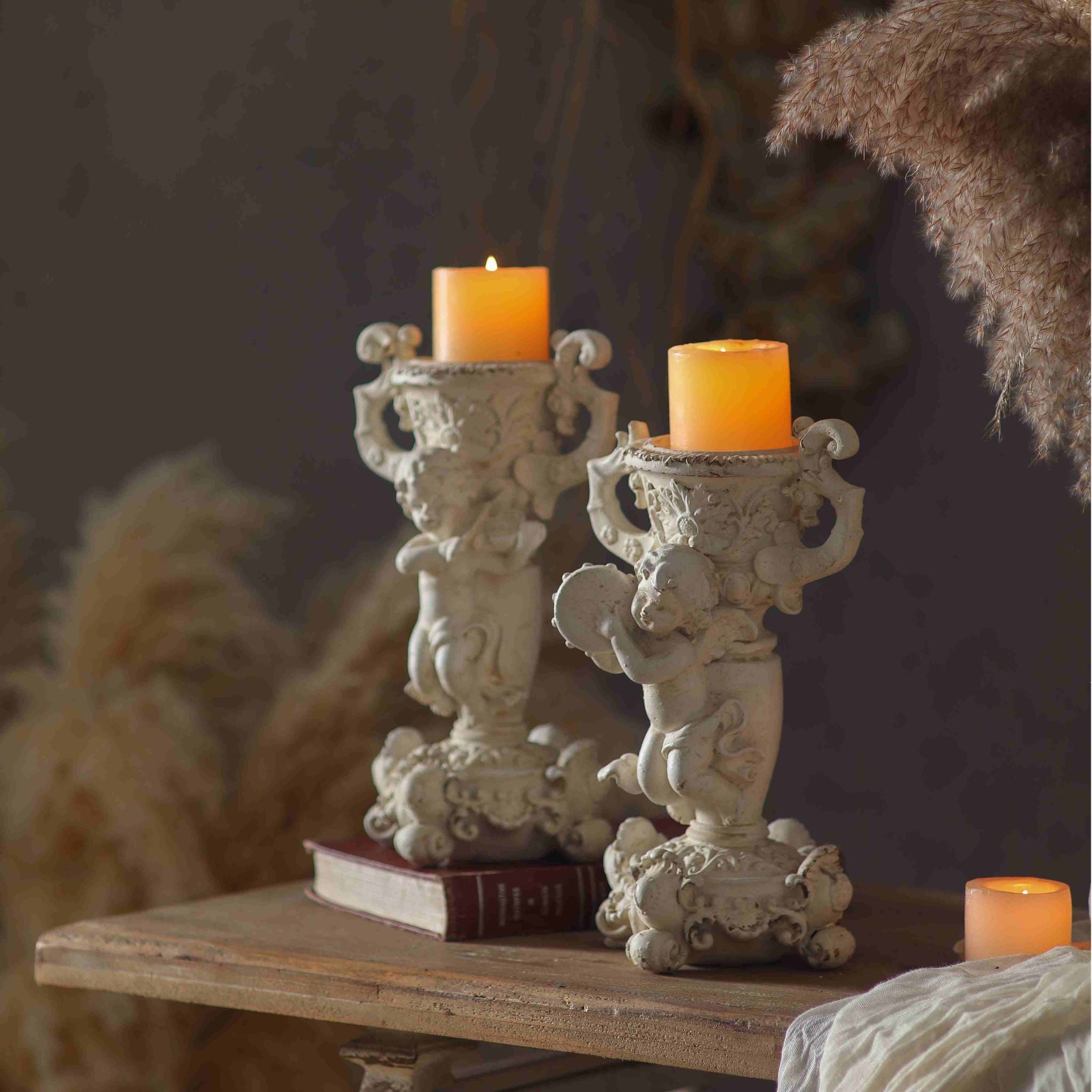 Jean Paul cherub candle holder shown lit beside its companion Claude, sold separately