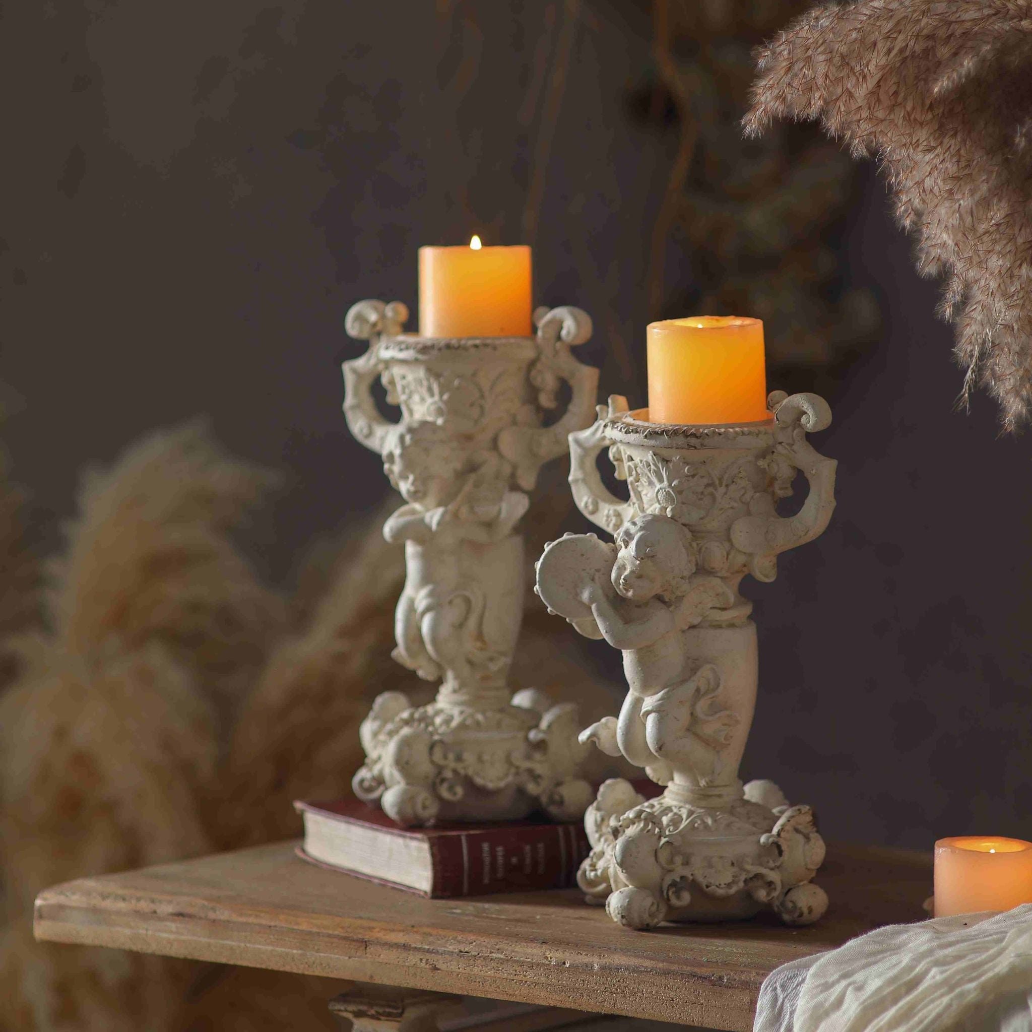 Jean Paul cherub candle holder shown lit beside its companion Claude, sold separately