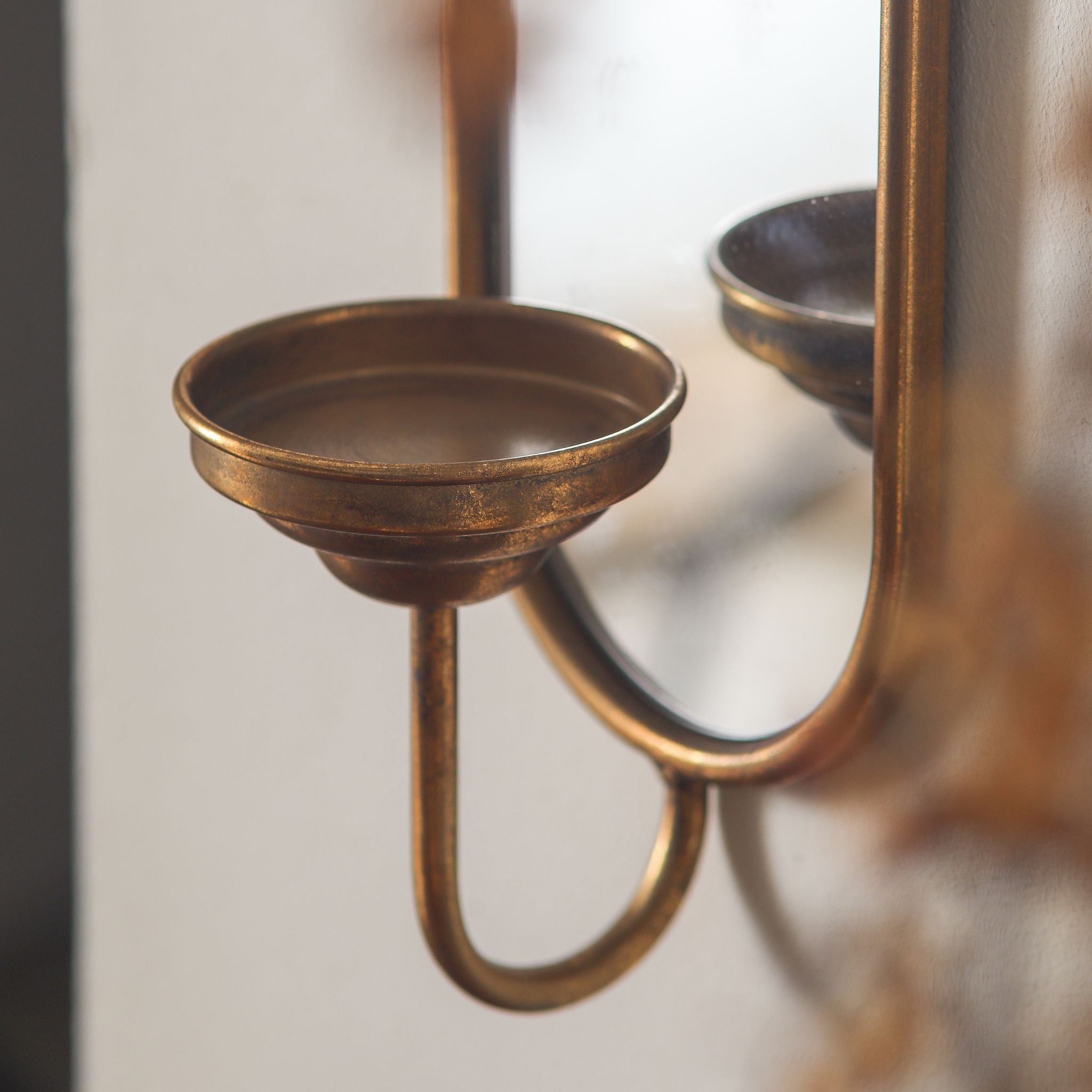 Detail of the Aude sconce aged gold candle cup and curved arm