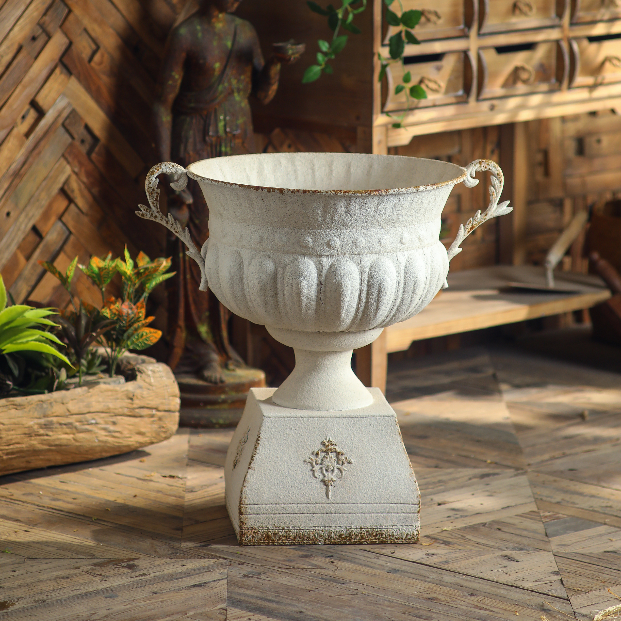 Front view of Héloïse iron urn planter with scrolled handles, fluted body and decorative plinth