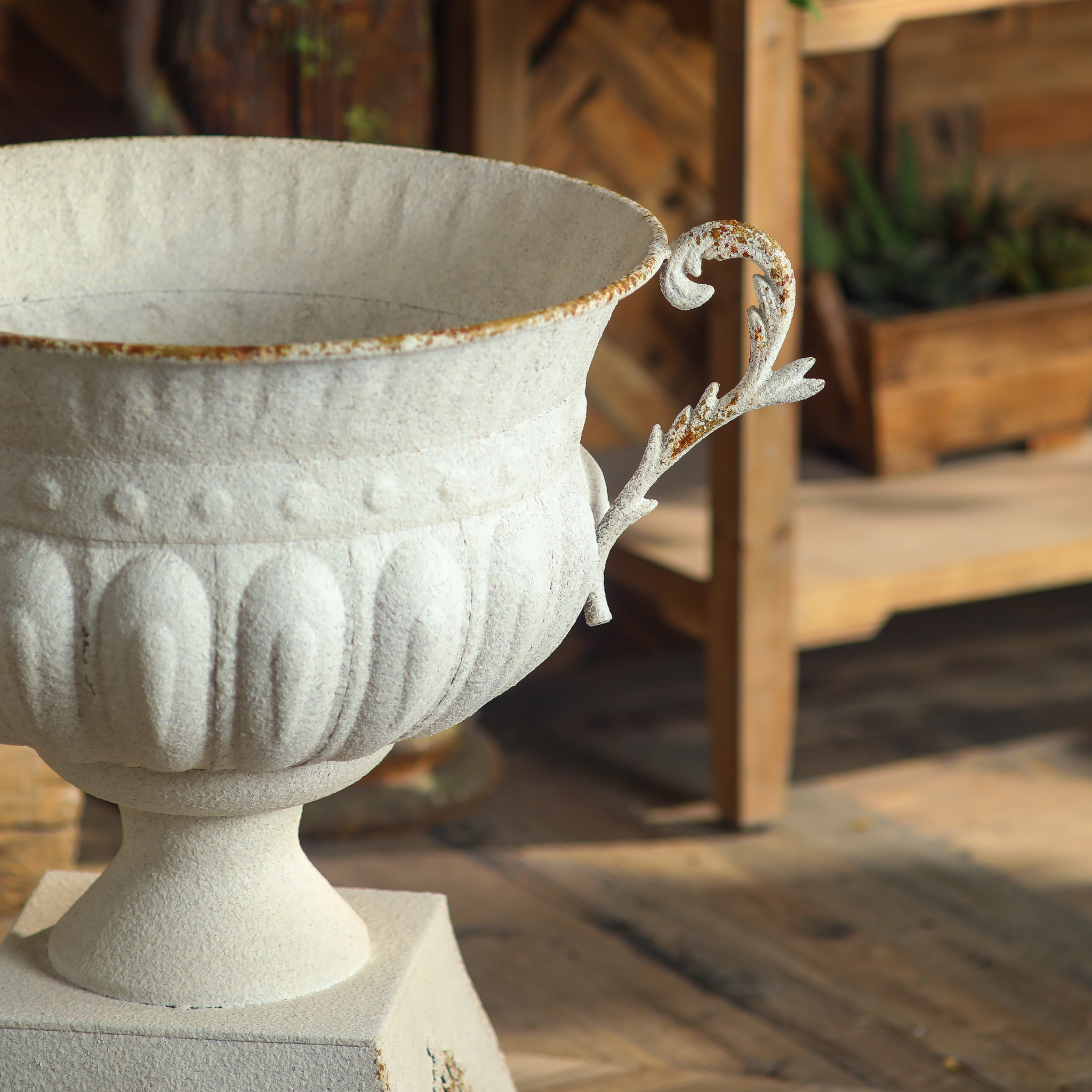 Close-up of Héloïse urn rim and handle showing aged iron rust patina