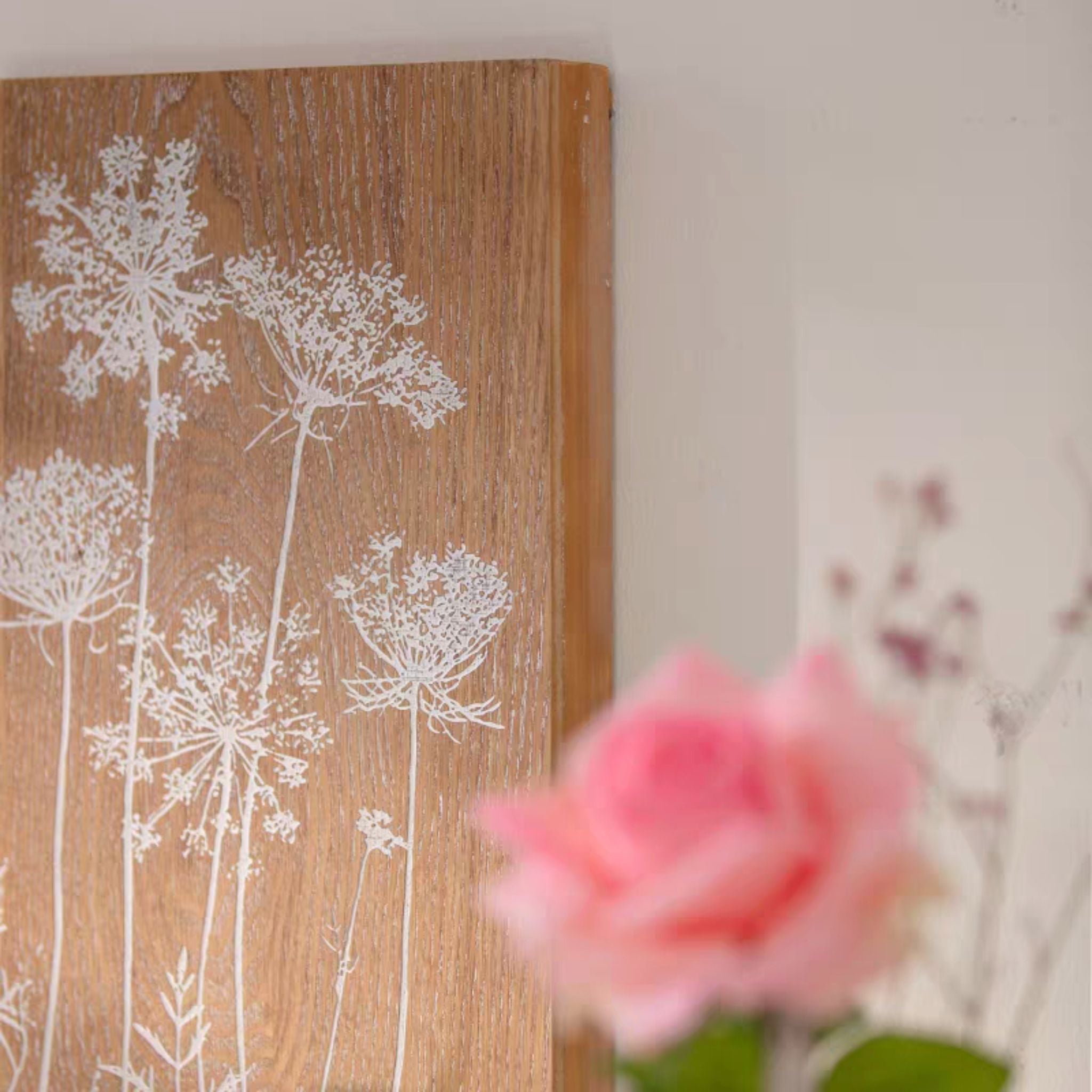 Close-up of the white wildflower print on the natural fir grain of the Hughette block.