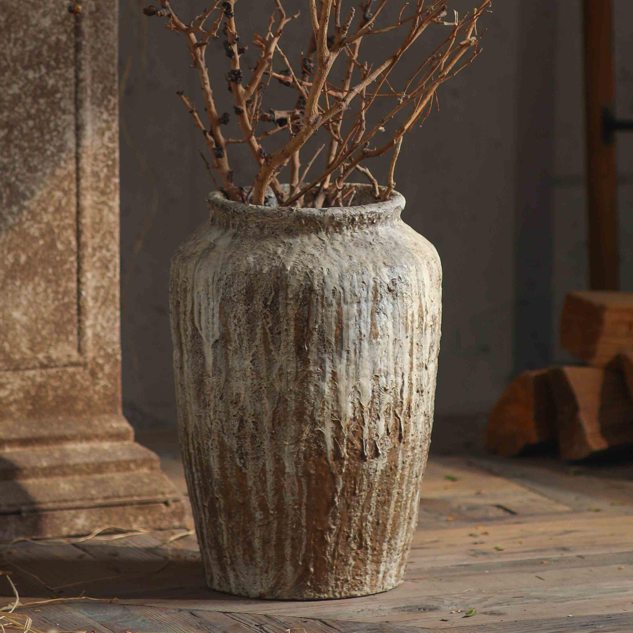 Jean-Marc weathered jar vase with dried branches, showing the dripped limewash texture down the body.