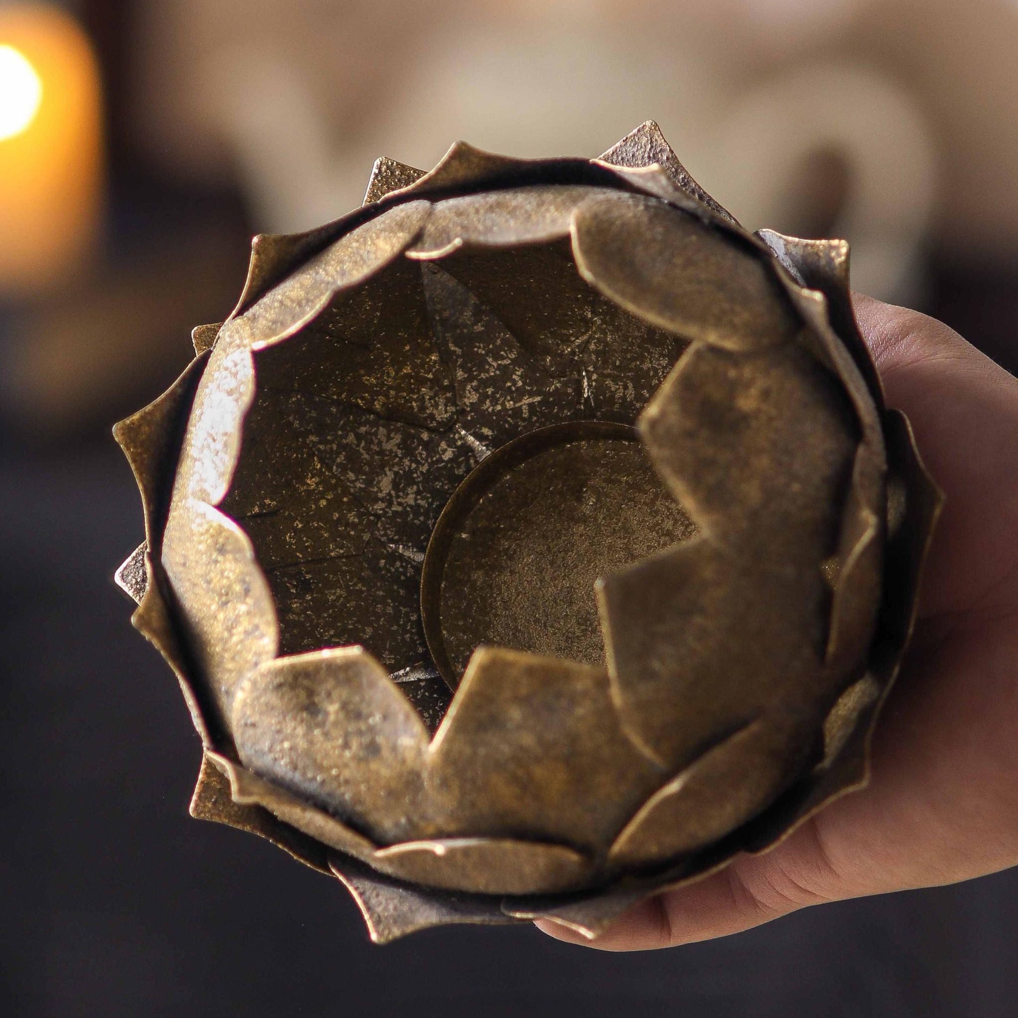 Top-down view of the lotus tealight holder interior and tealight cup, antique gold mottled finish.