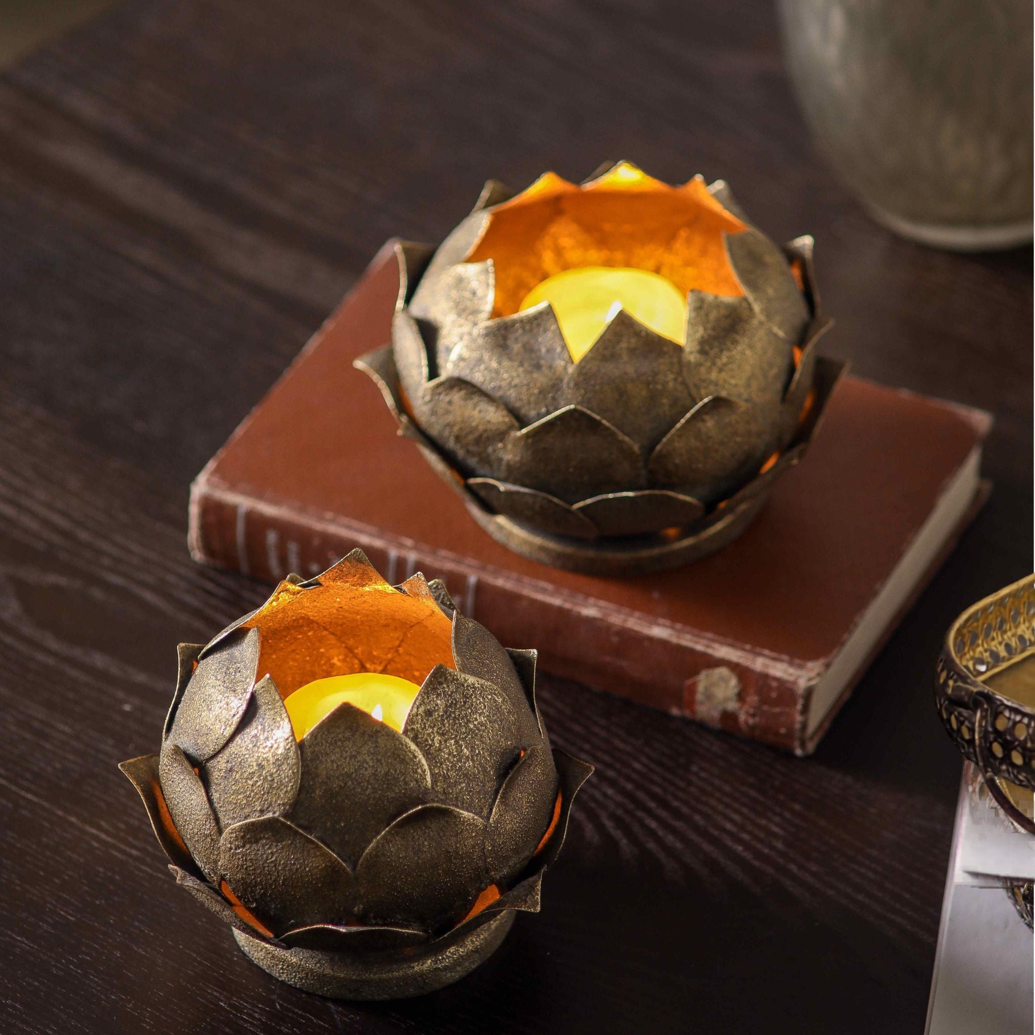 Lotus tealight holders lit, showing the tealight inside and the gilded gold interior of each flower.