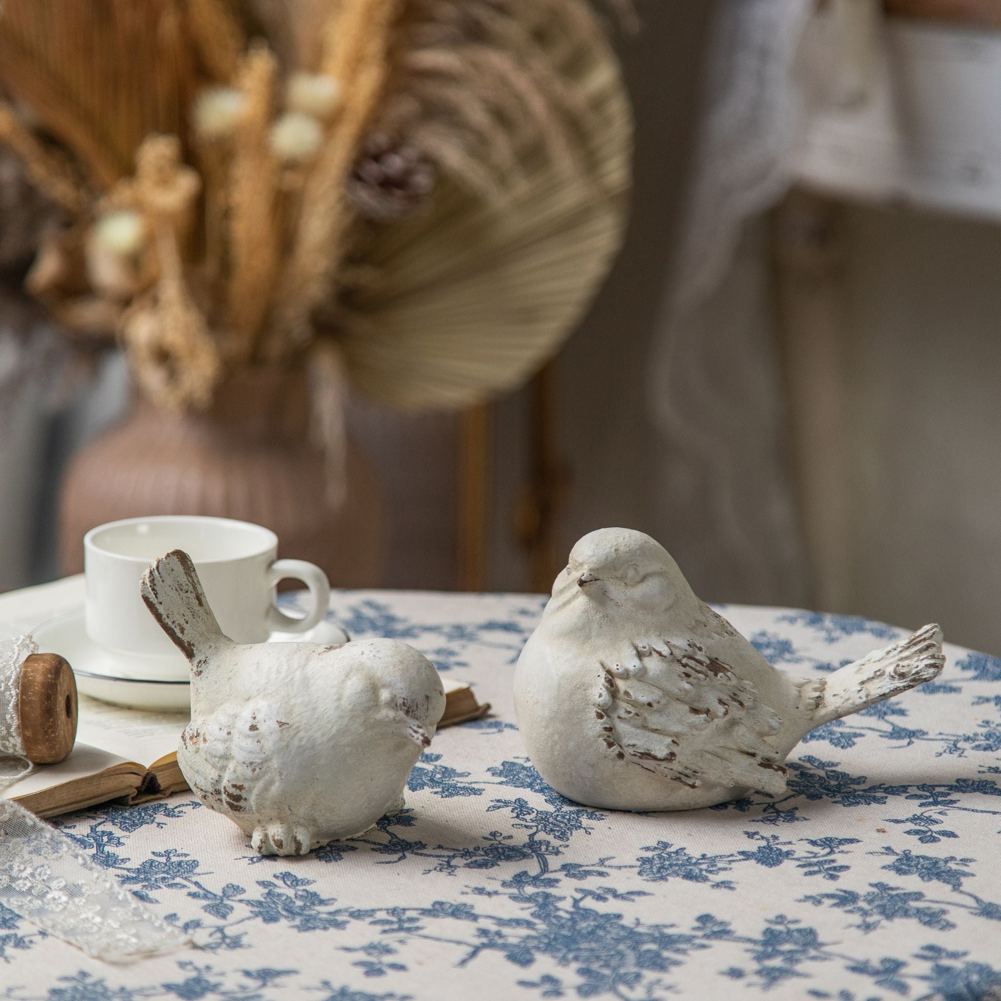 Lucas French Provincial bird figurines set of two on blue toile cloth with teacup. Hero