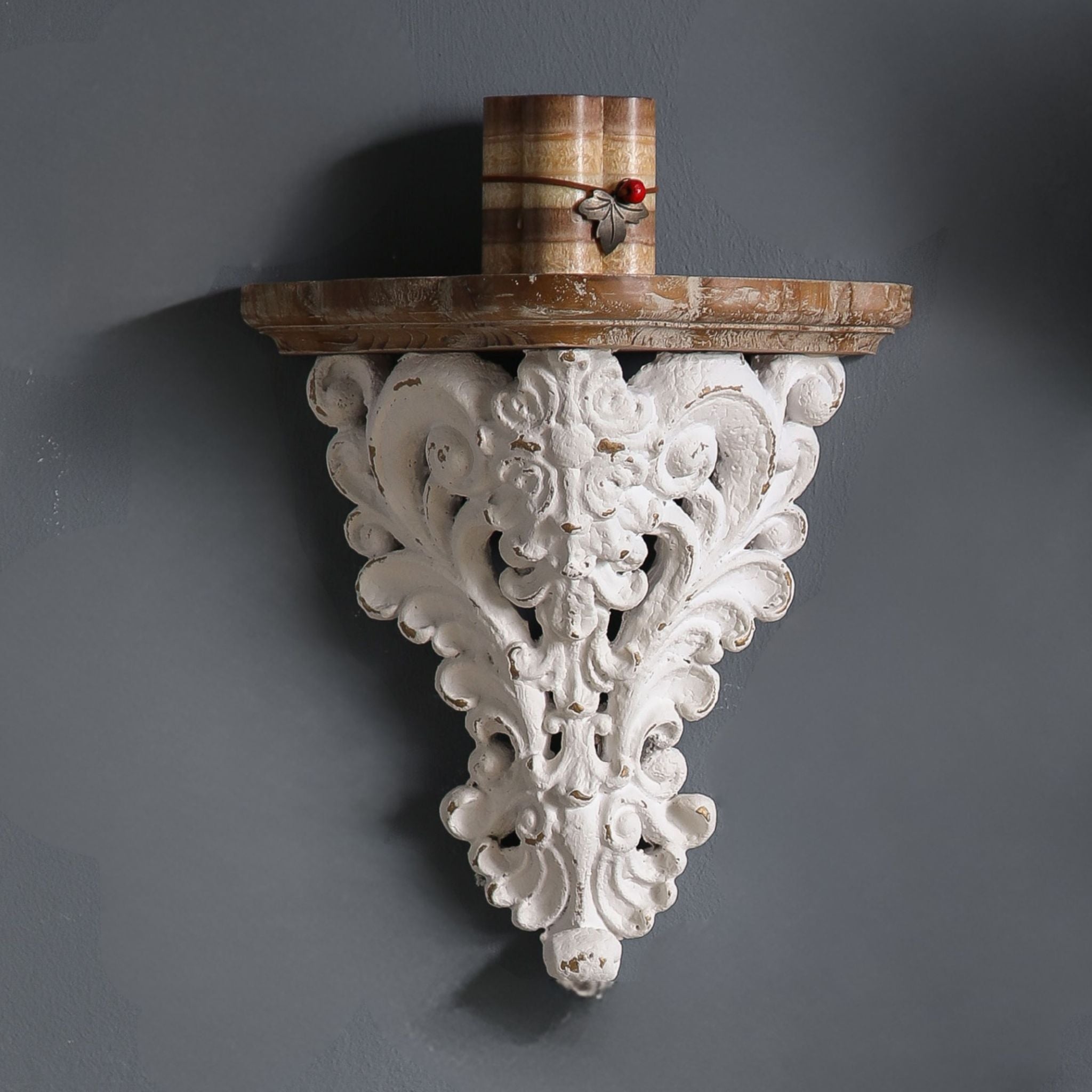 Close-up of Marguerite corbel showing the carved scroll and rosette detail, distressed whitewash finish, and the warm timber top shelf