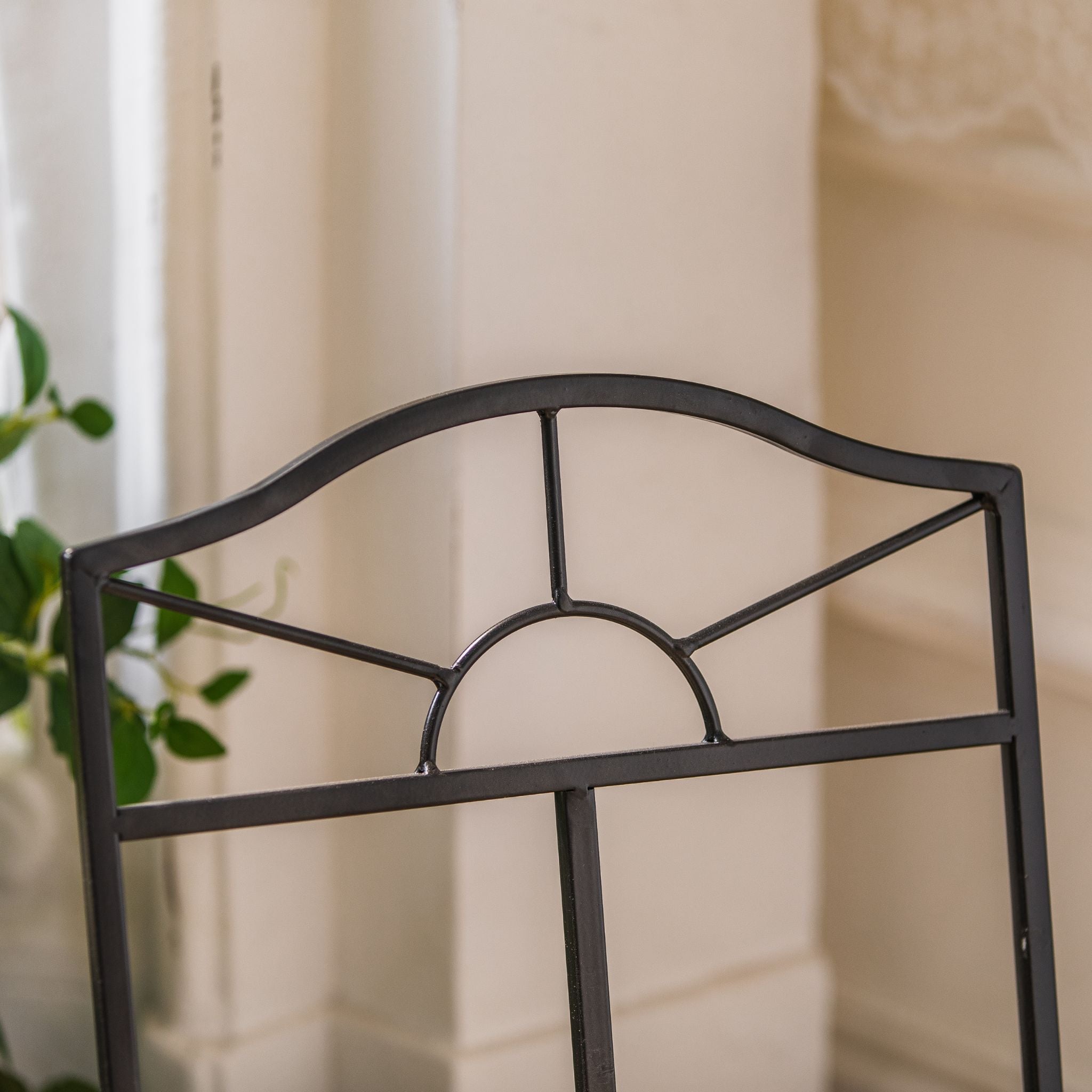 Close-up of the sunburst fan motif worked into the arched top of the Adrien log holder.