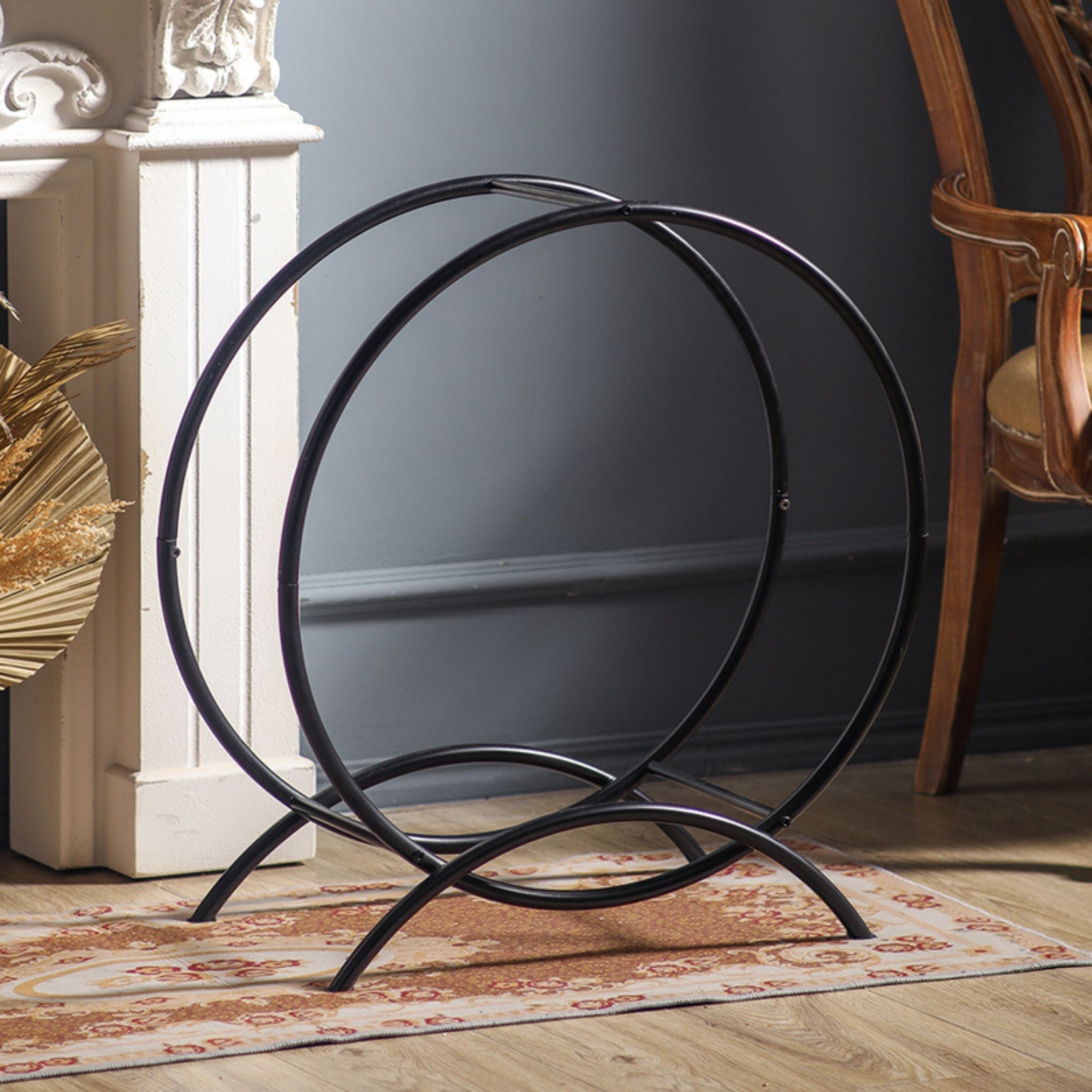 Angled view of the empty Emeric round log hoop showing its double-ring frame and crossed feet.