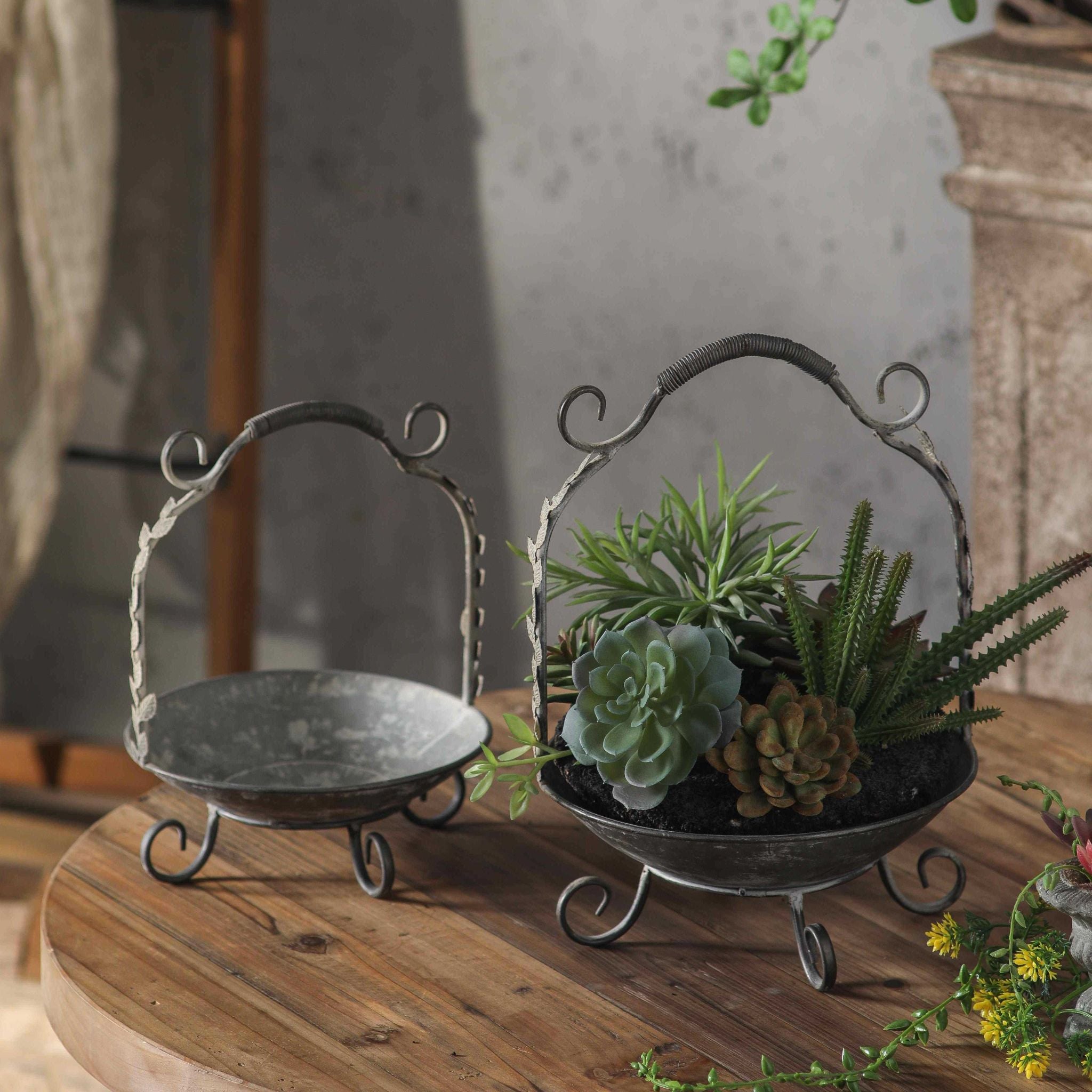 Meline French Provincial handled baskets, set of two in distressed zinc metal with scrolled feet and arched leaf handles. Hero.