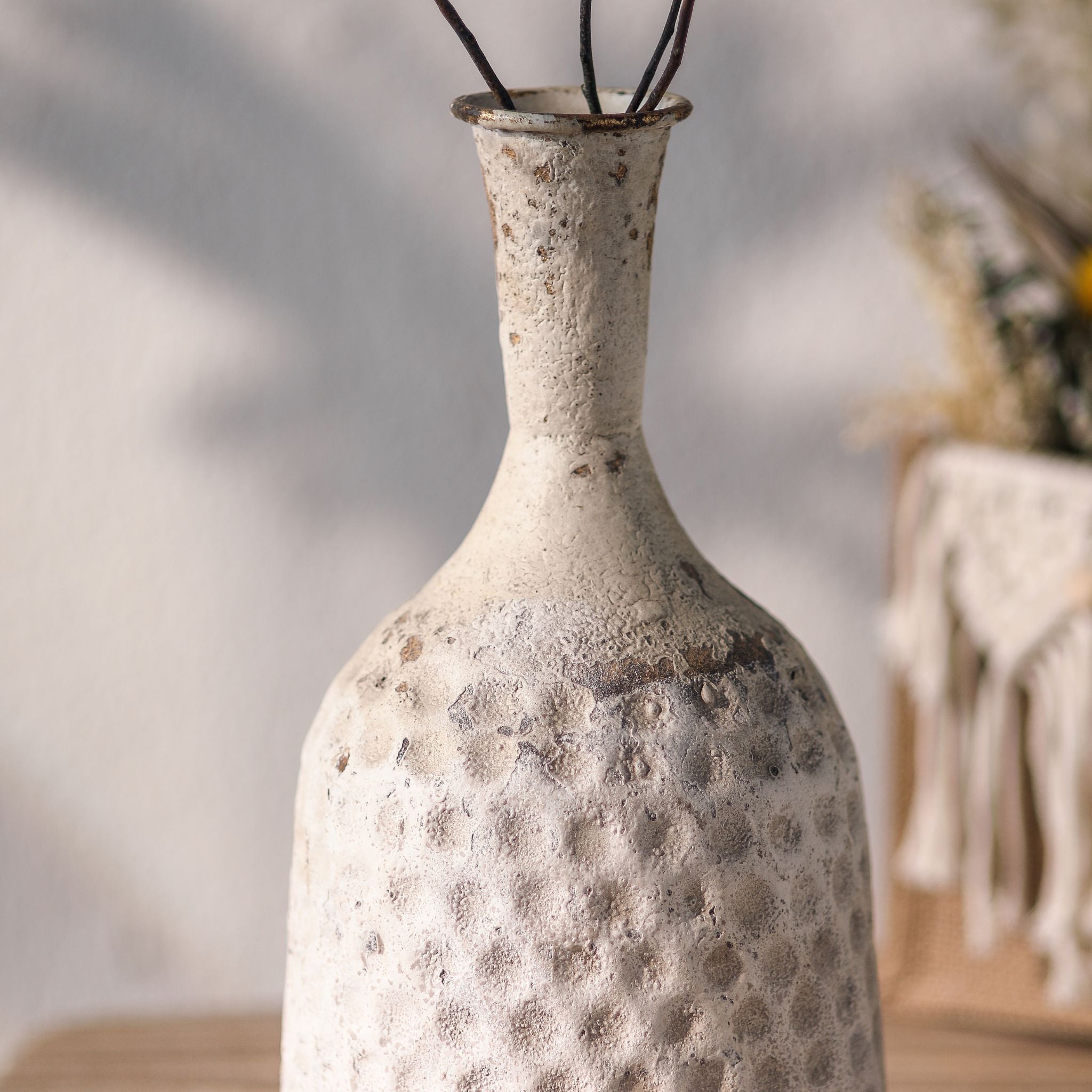 Michelle bottle vase close-up of the hammered dimpled body and distressed white over rust-gold finish