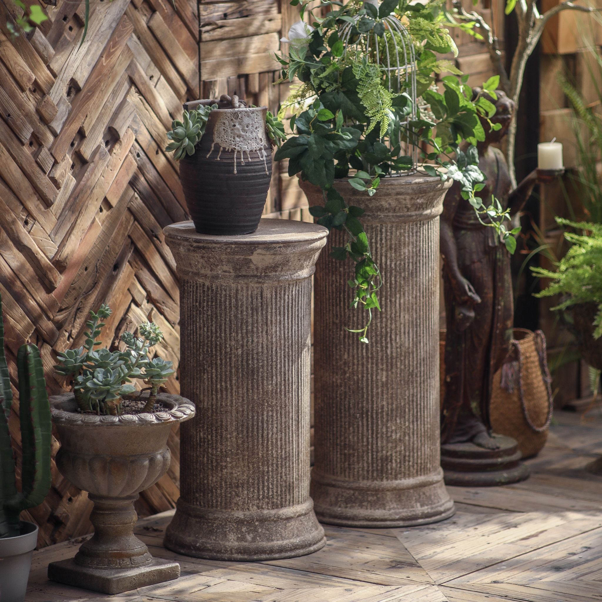 Mireille column pedestal styled in a French Provincial courtyard, shown with its taller companion column.