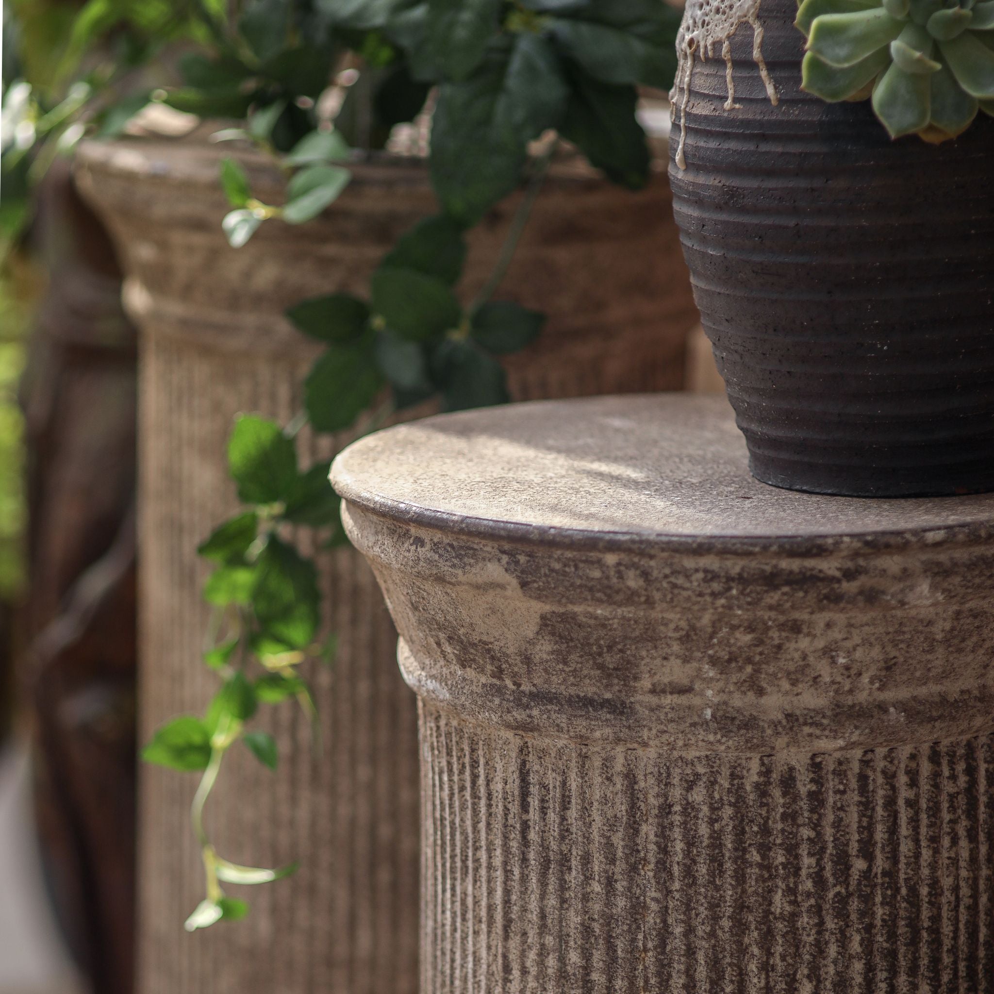 Mireille column pedestal, close detail of the moulded top rim, fluting and weathered finish.