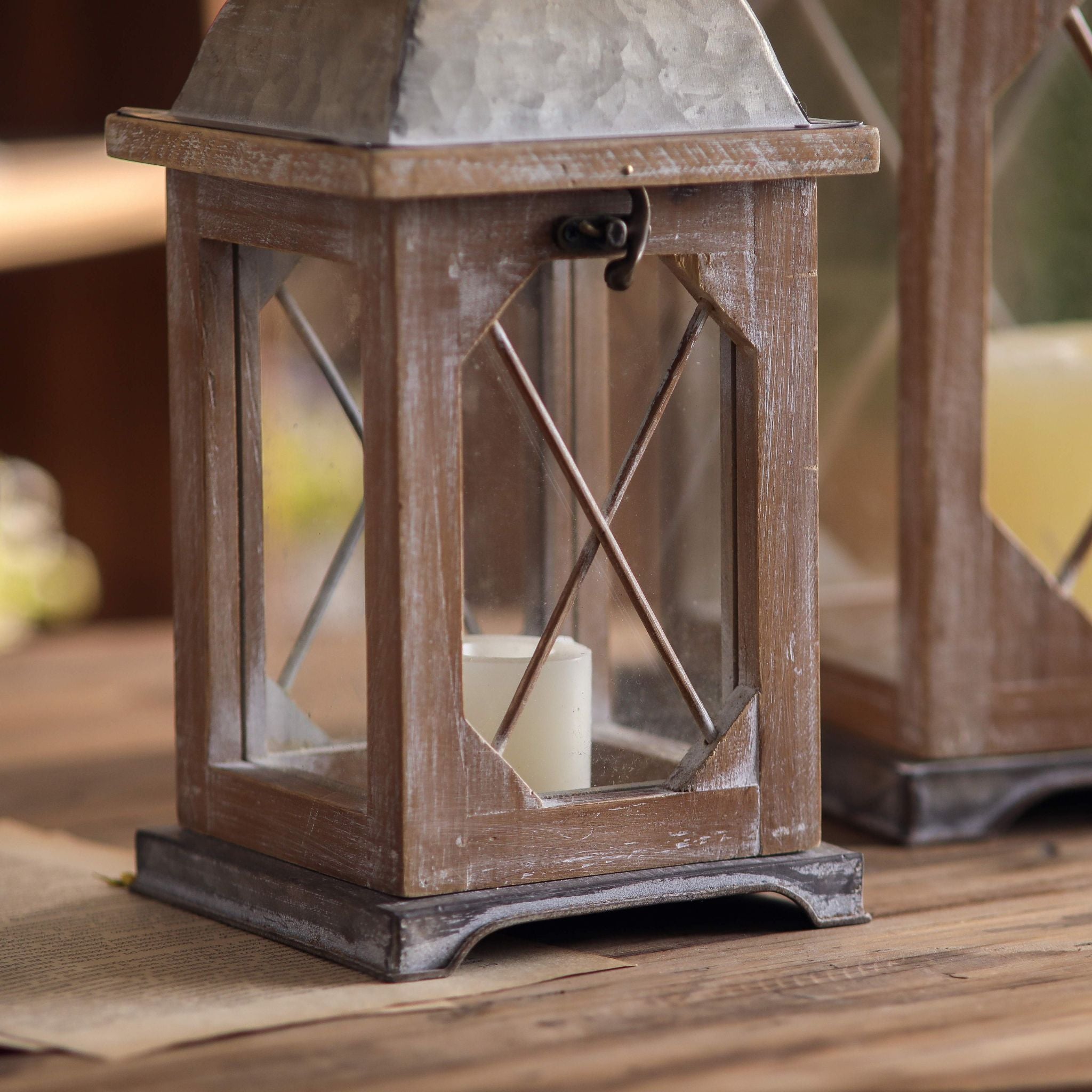 Whitewashed wood lantern base with crossed lattice and a pillar candle inside