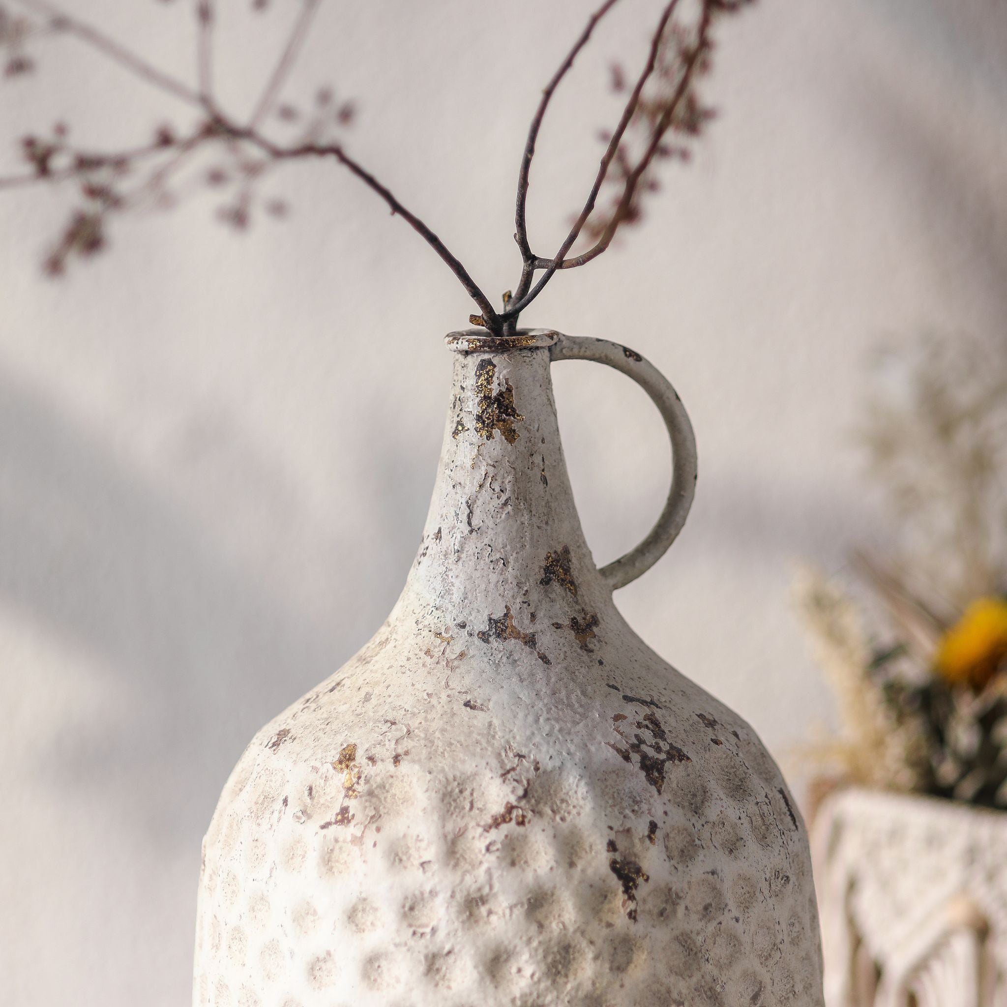 Noemie jug vase close-up of the loop handle, neck and distressed white over rust-gold finish