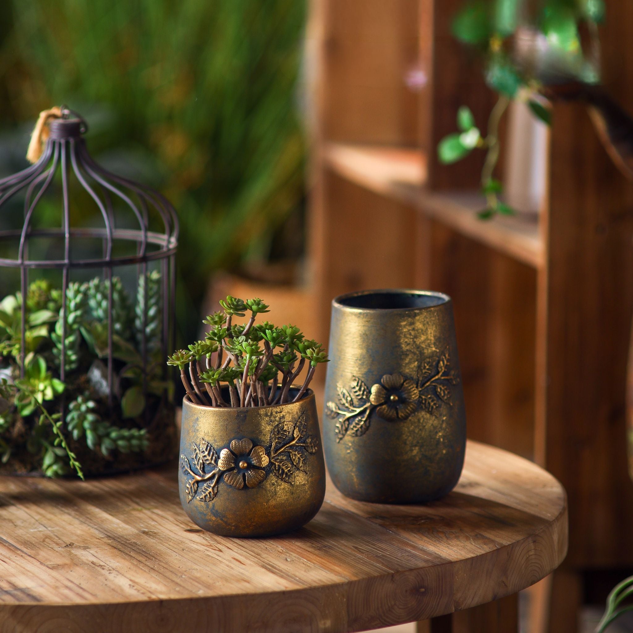 Normandy pair of pots styled on a round table with a planted terrarium behind.