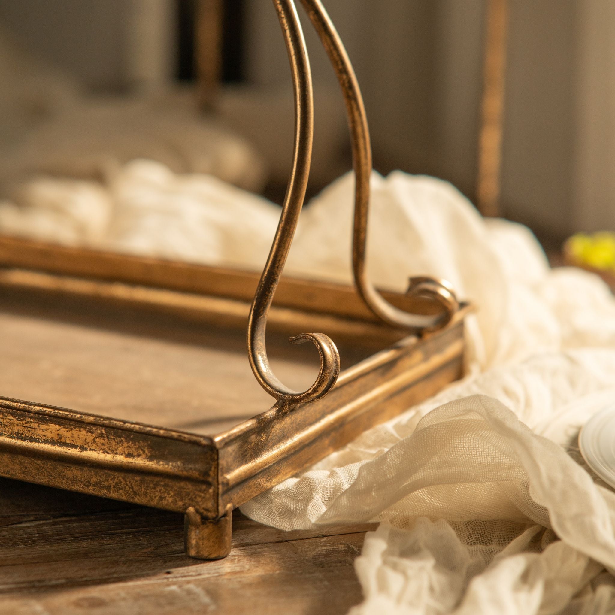 Edge and foot detail of the antique gold metal frame on the Risette tray.