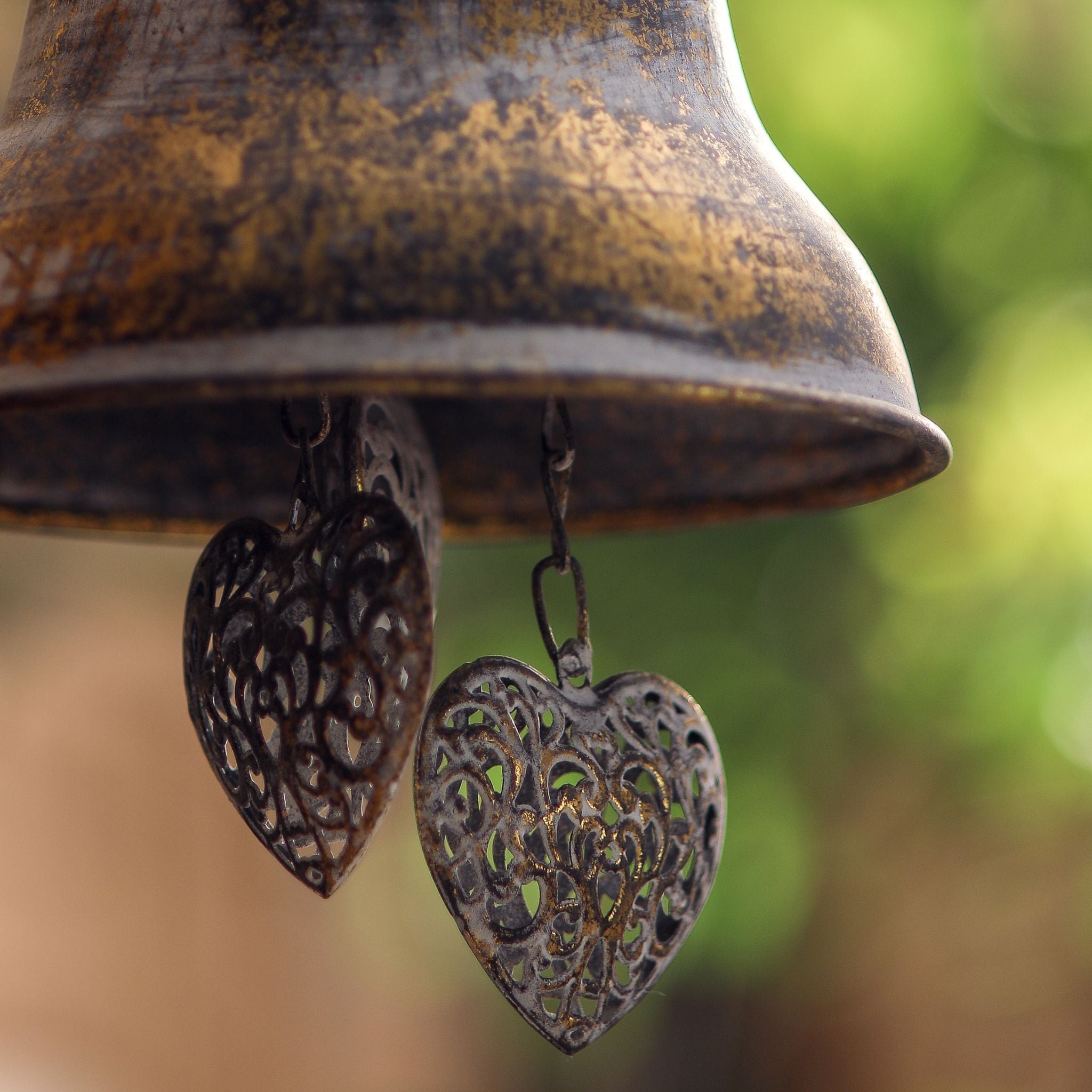 Rochelle hanging bell detail of the pierced filigree metal hearts hanging below the bell.
