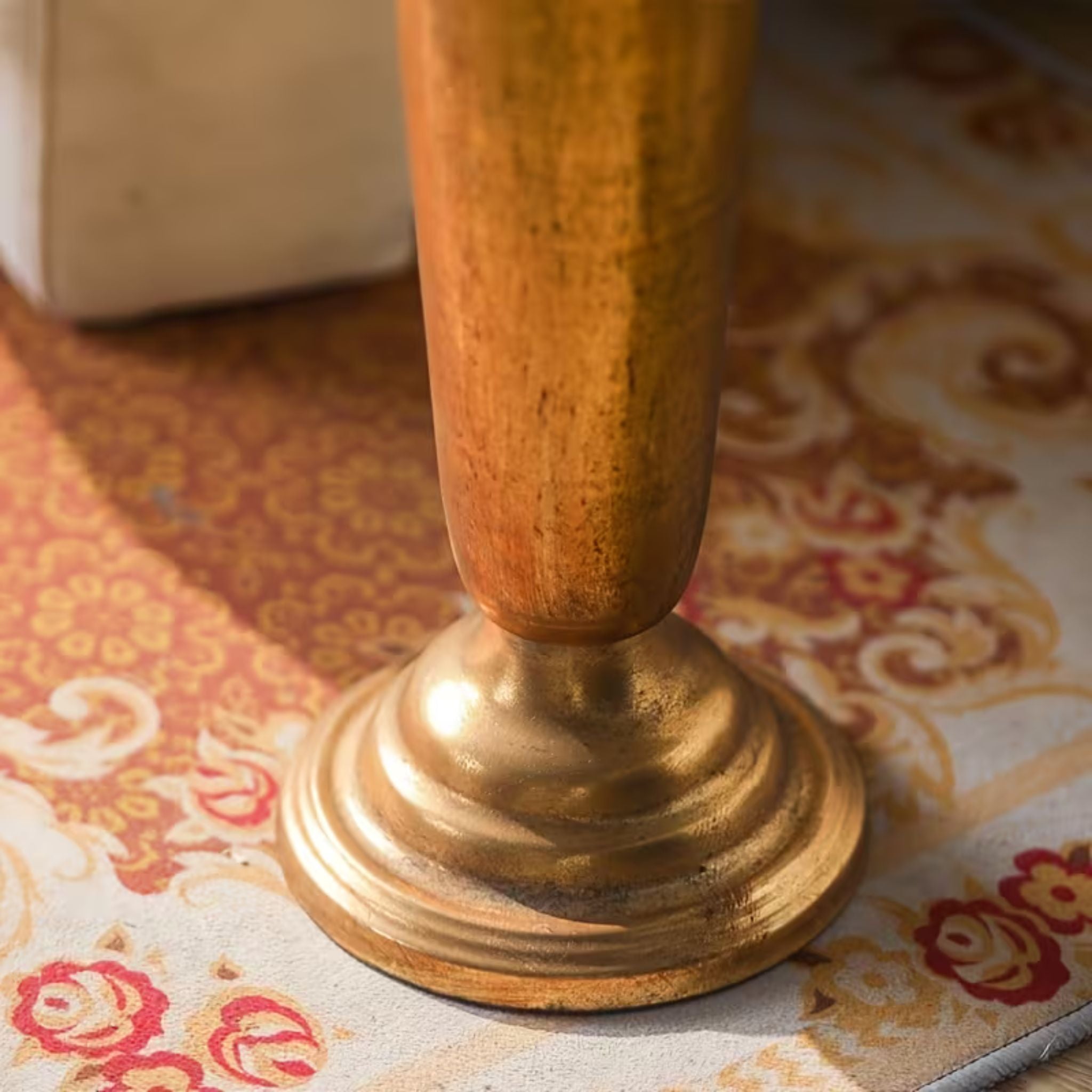 Tapering body and flared foot of the Theo Victor umbrella stand in gold.