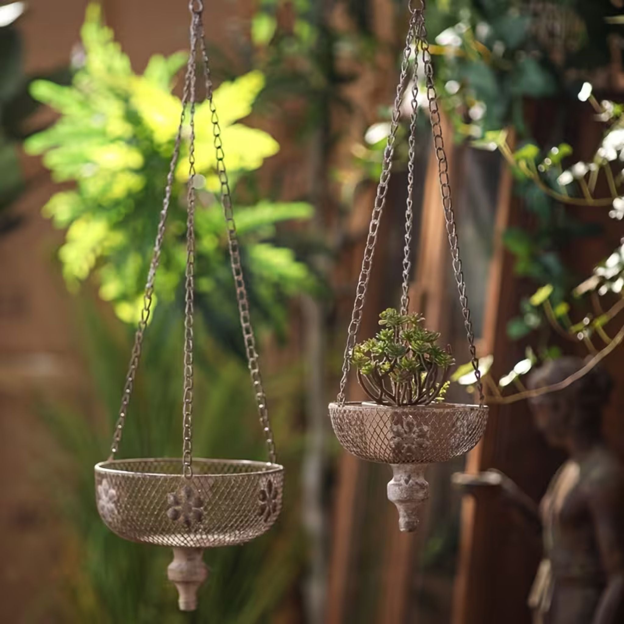 Toulouse set of two vintage hanging chain planters in distressed metal mesh, one planted with succulents. Hero.