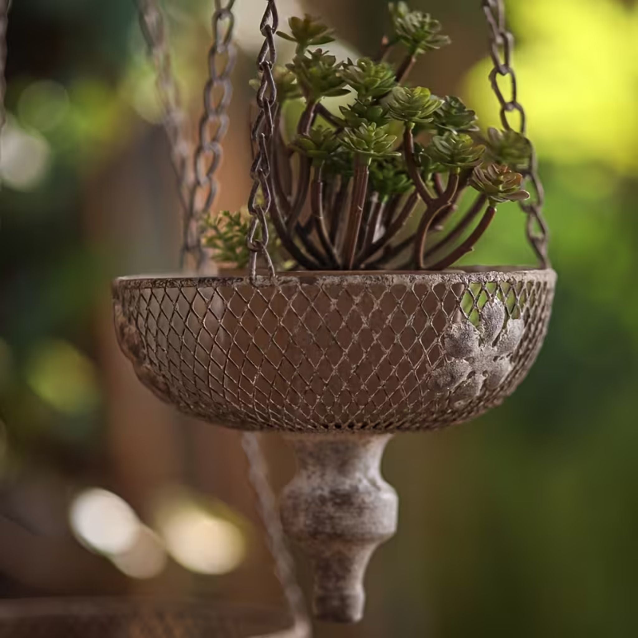 Toulouse hanging planter, detail of the mesh bowl, embossed flowers, and turned finial.