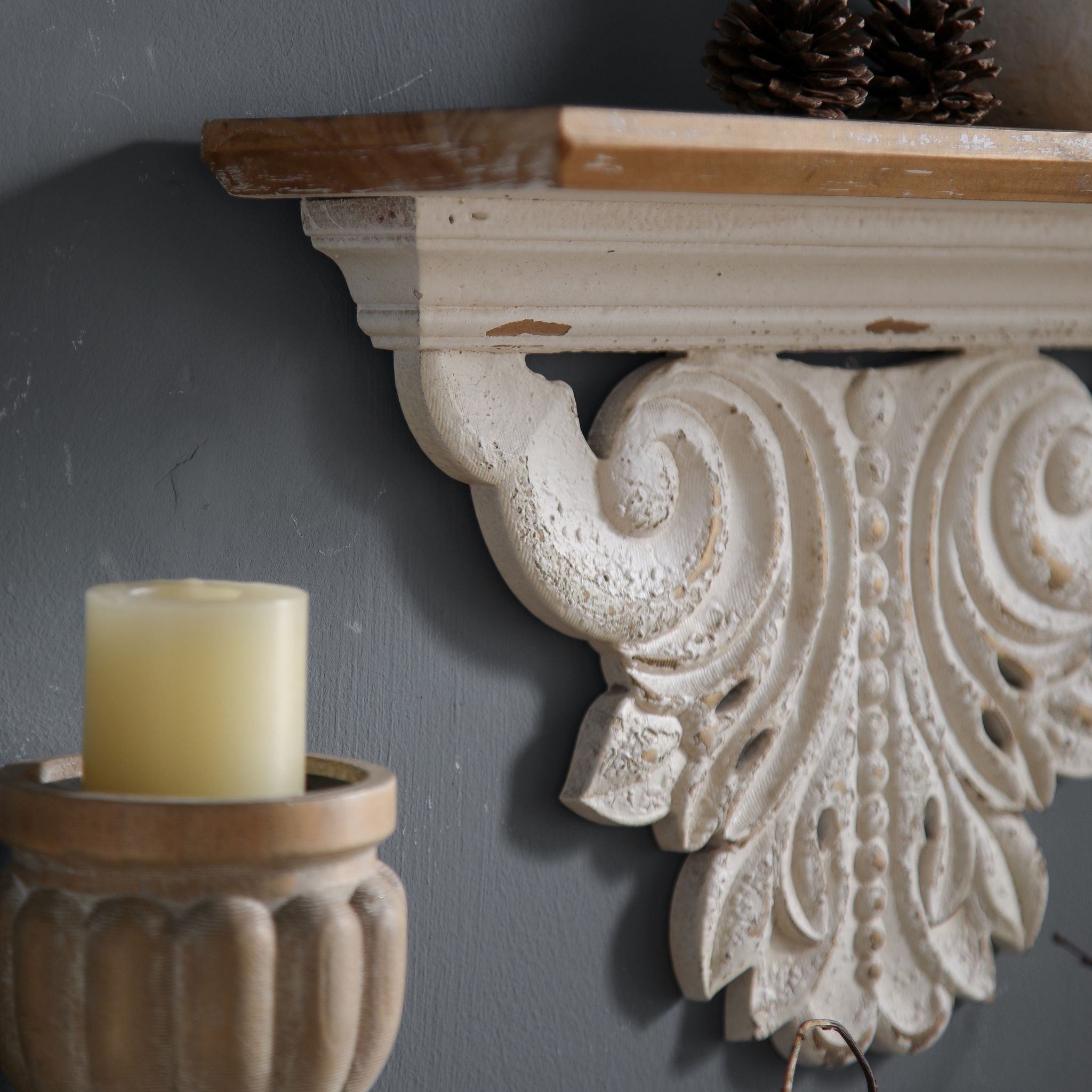 Close-up of Virginie mantel shelf showing the deep S-scroll carving, beaded central motif, and warm timber top side view