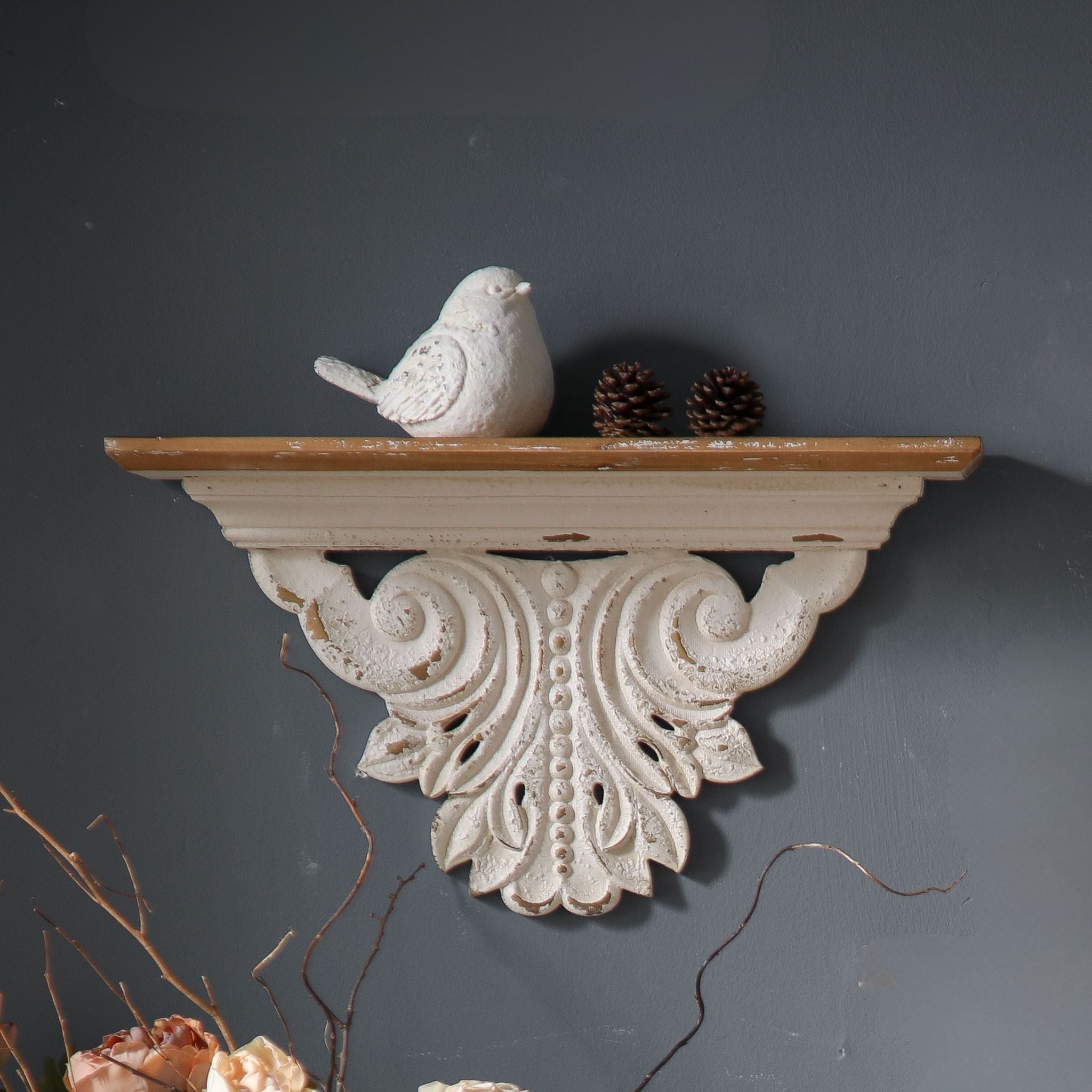 Close-up of Virginie mantel shelf showing the deep S-scroll carving, beaded central motif, and warm timber top