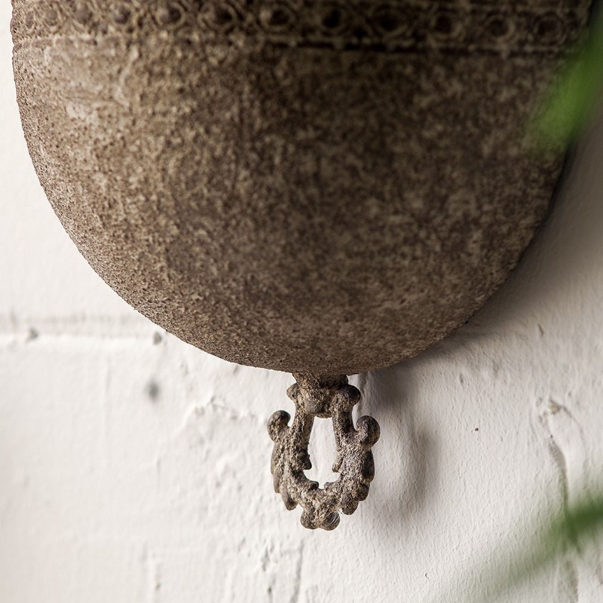 Close-up of the scrolled ring pendant at the base of the Sabine wall planter