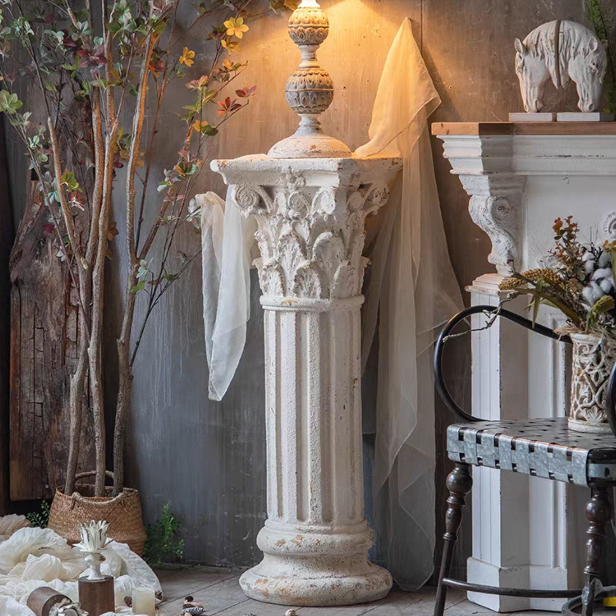 Yvonne column pedestal styled in a château-style room with a sheer drape and a finial on top.