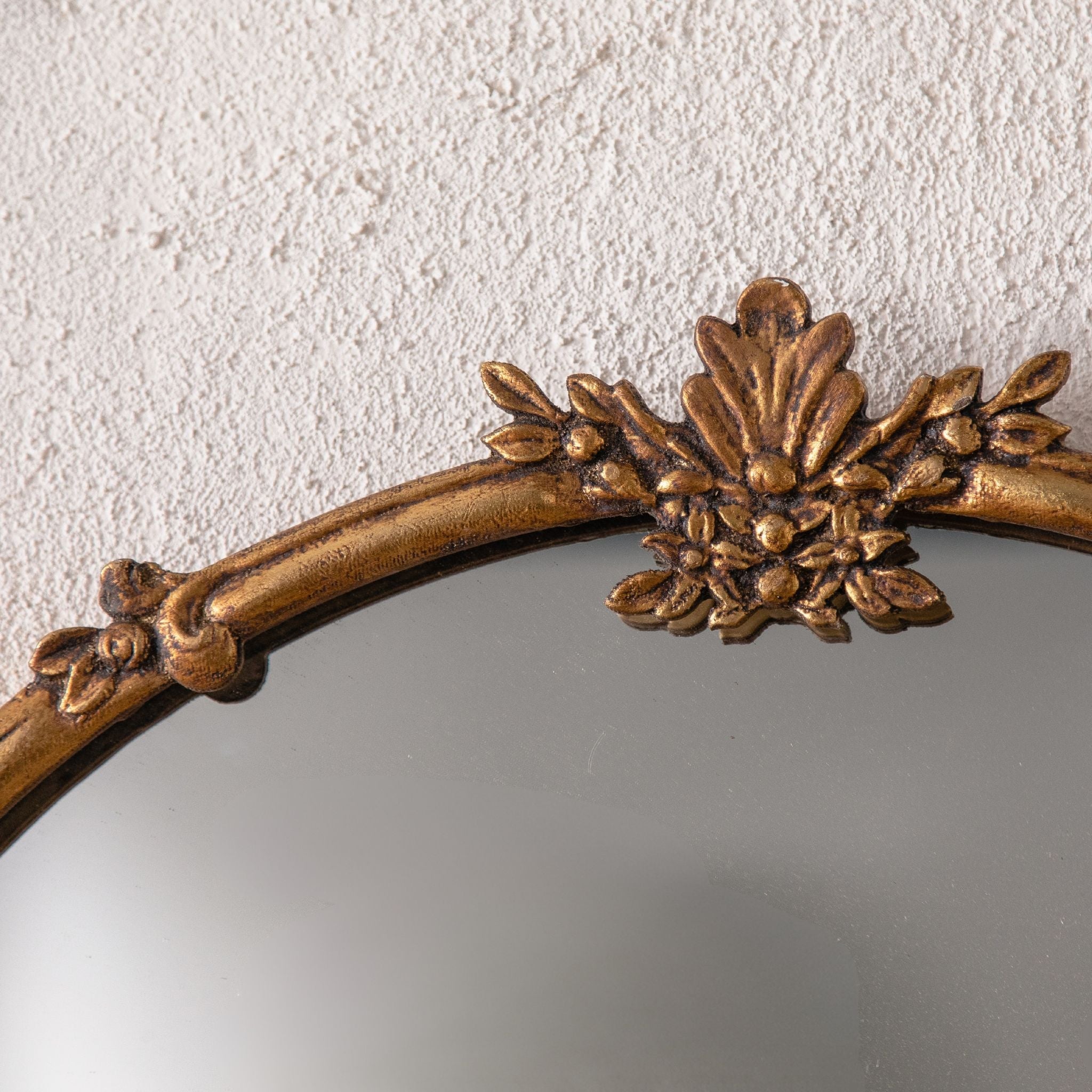 Close view of the cast leaf and berry crest on the Serena mirror frame