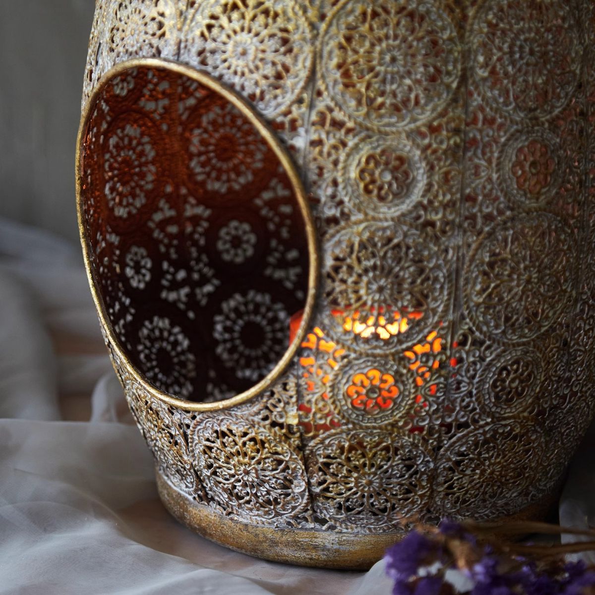 Side view of the openwork aged metal lantern showing the pierced pattern