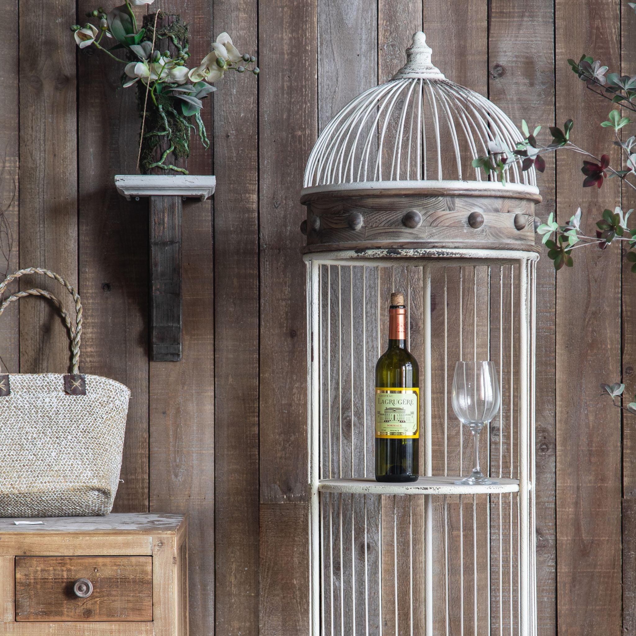 Wine bottle and glass on a timber shelf inside the Brindisi birdcage display shelf