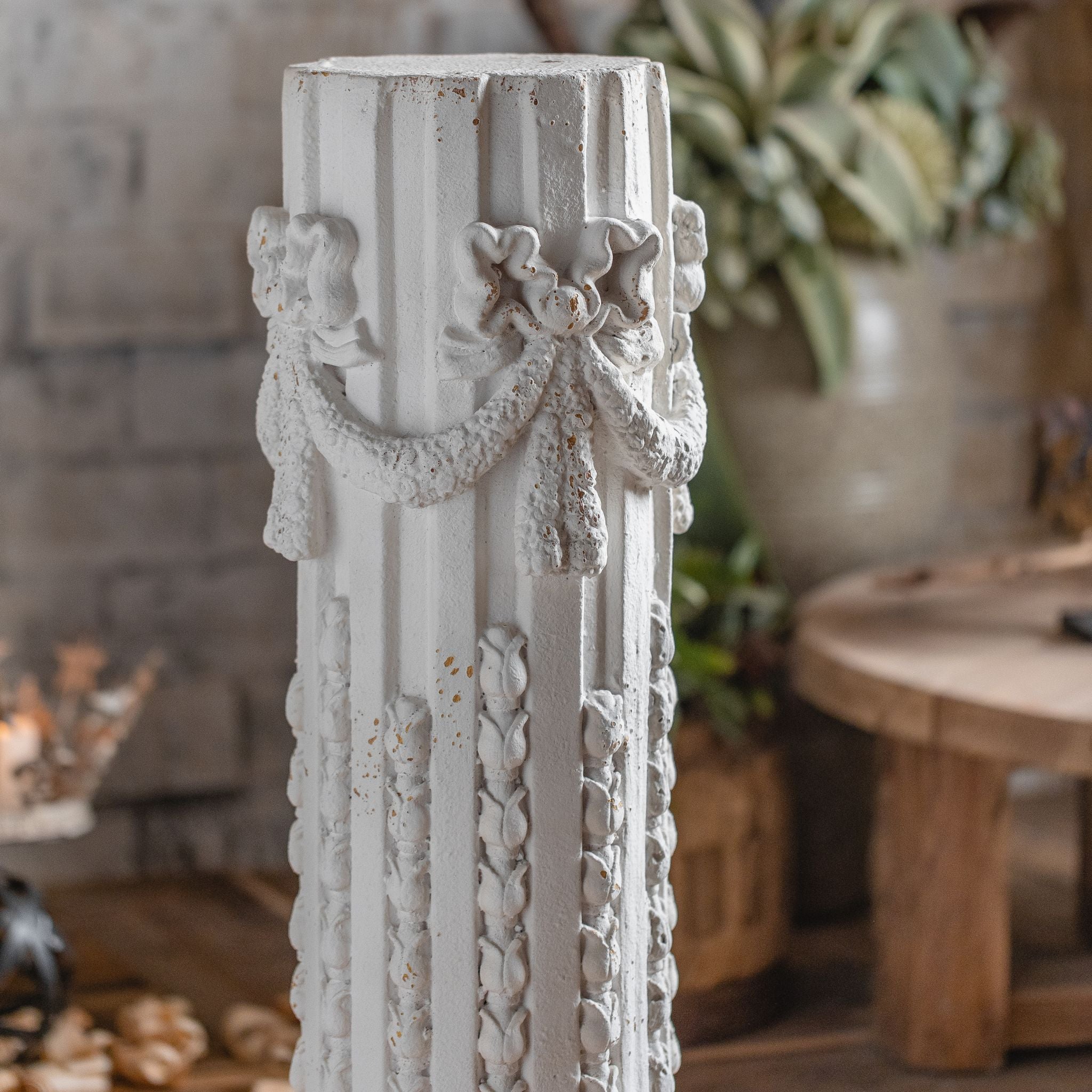 Bruna column pedestal styled with an urn of lemon branches against a whitewashed brick wall