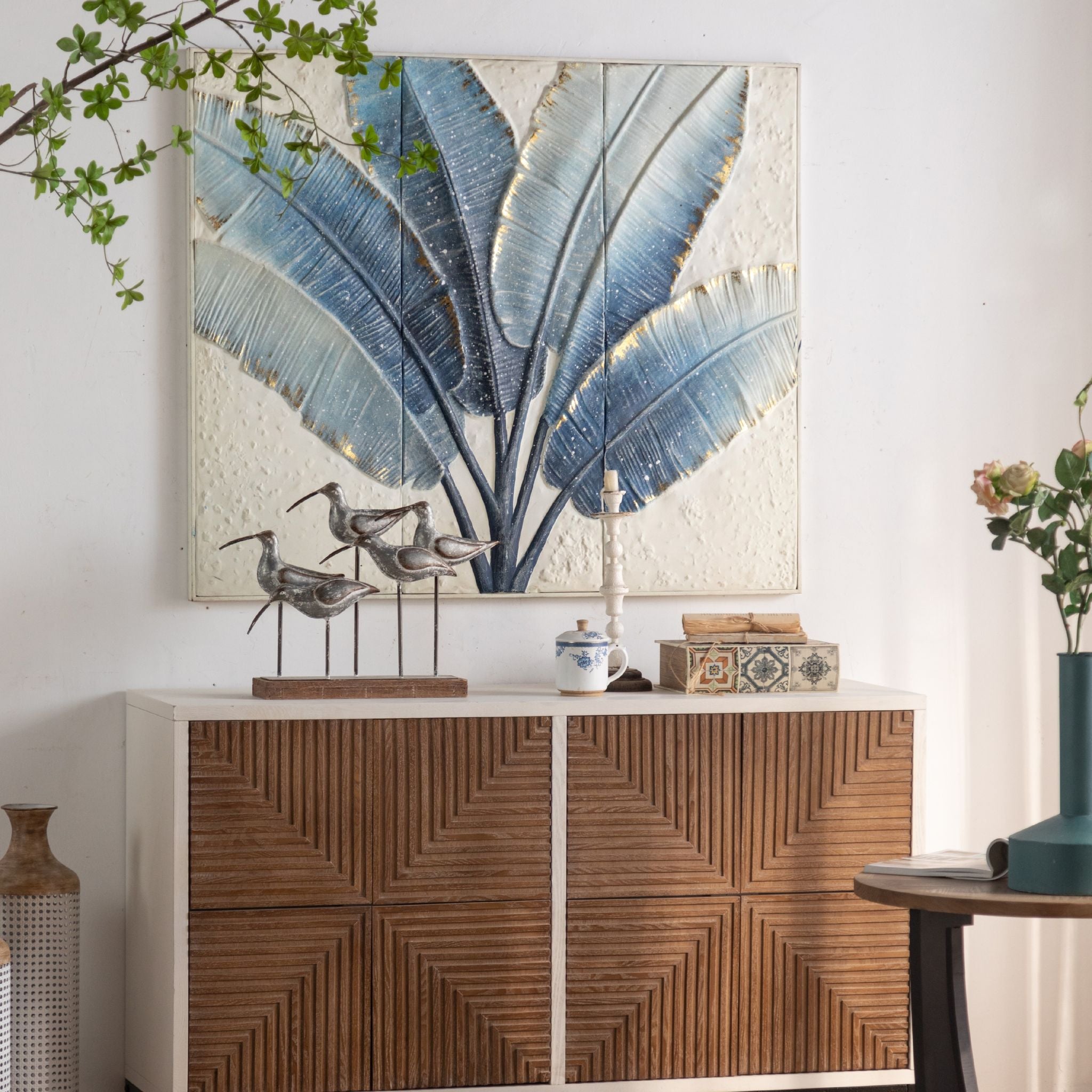 Tino blue leaf wall panel styled above a timber cabinet with decor