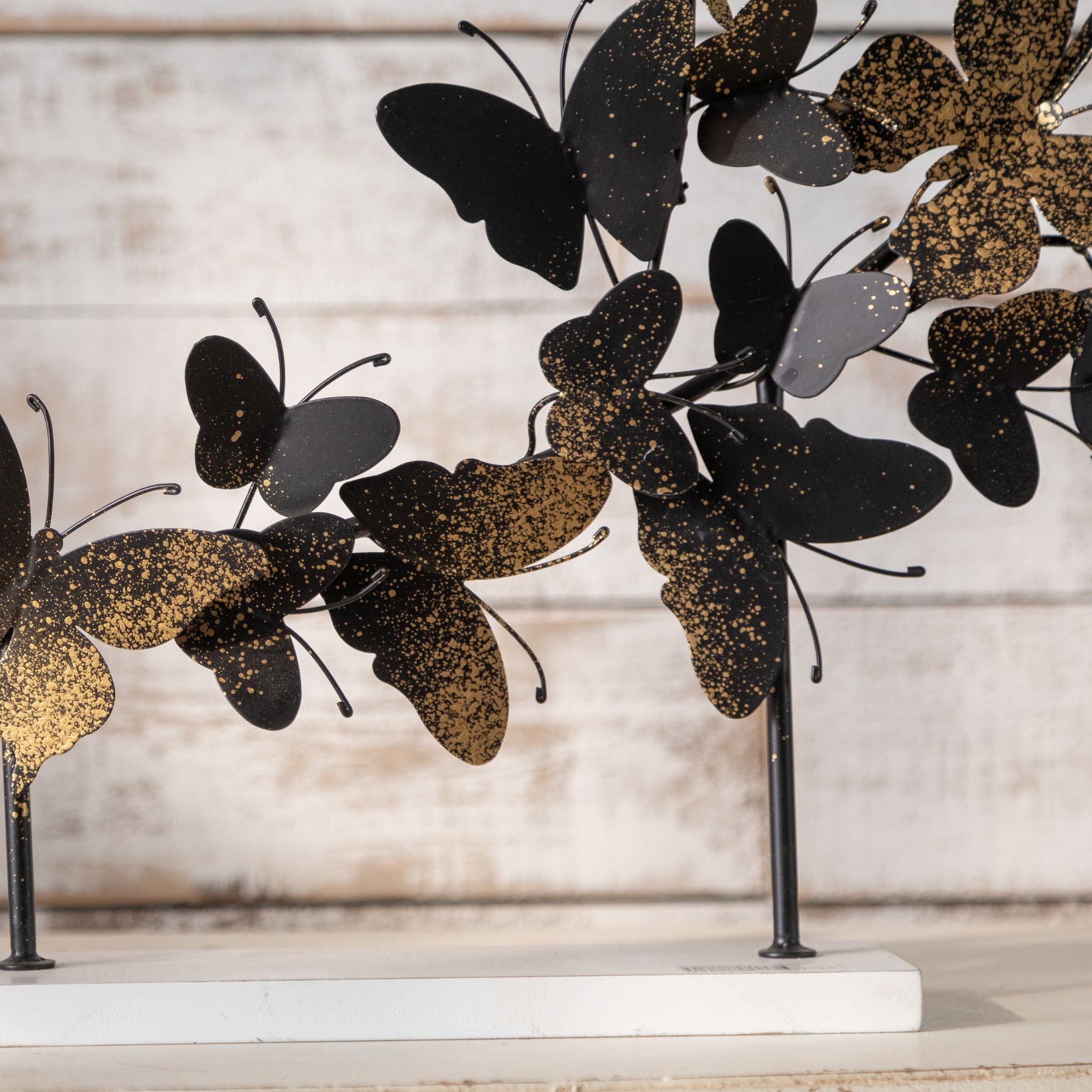 Close view of the gold speckled butterfly wings and base fixing on the Tessa sculpture