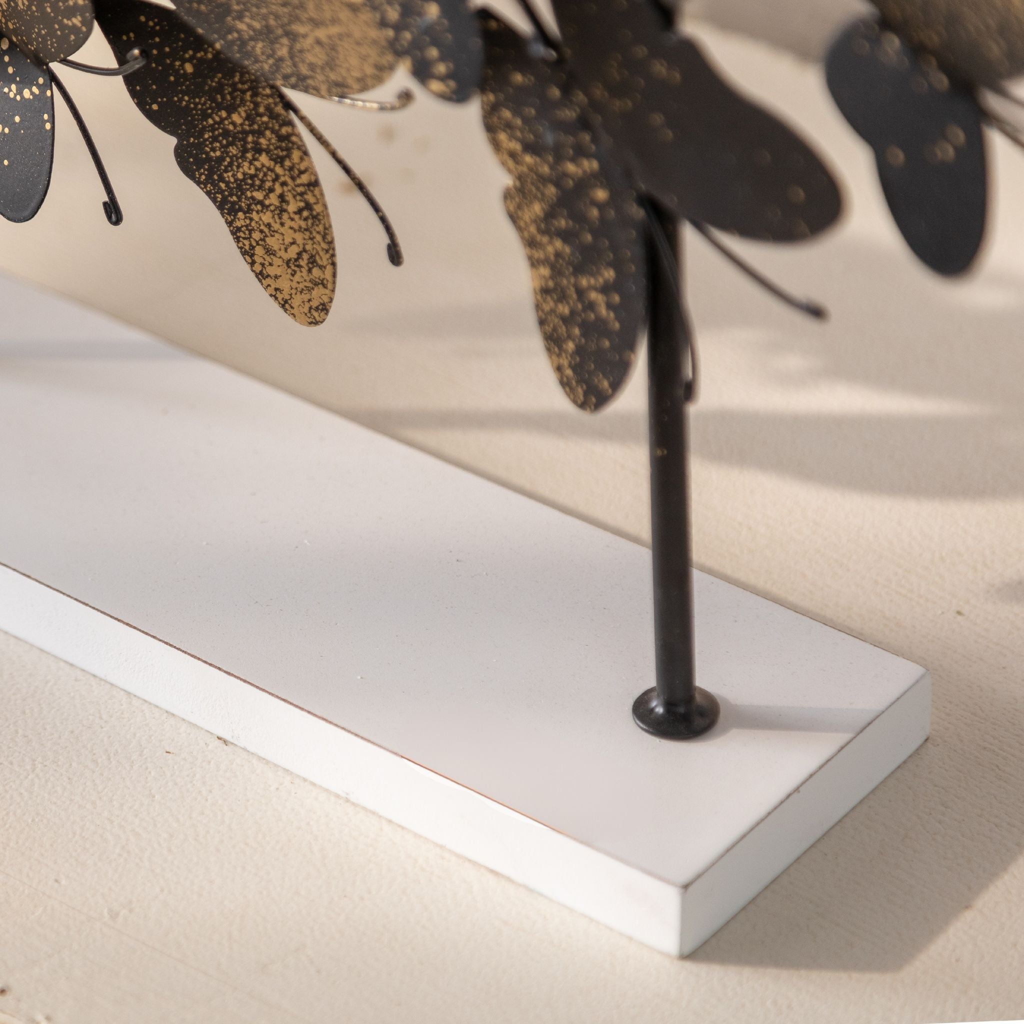 Detail of the black and gold butterflies rising along the Tessa sculpture branches