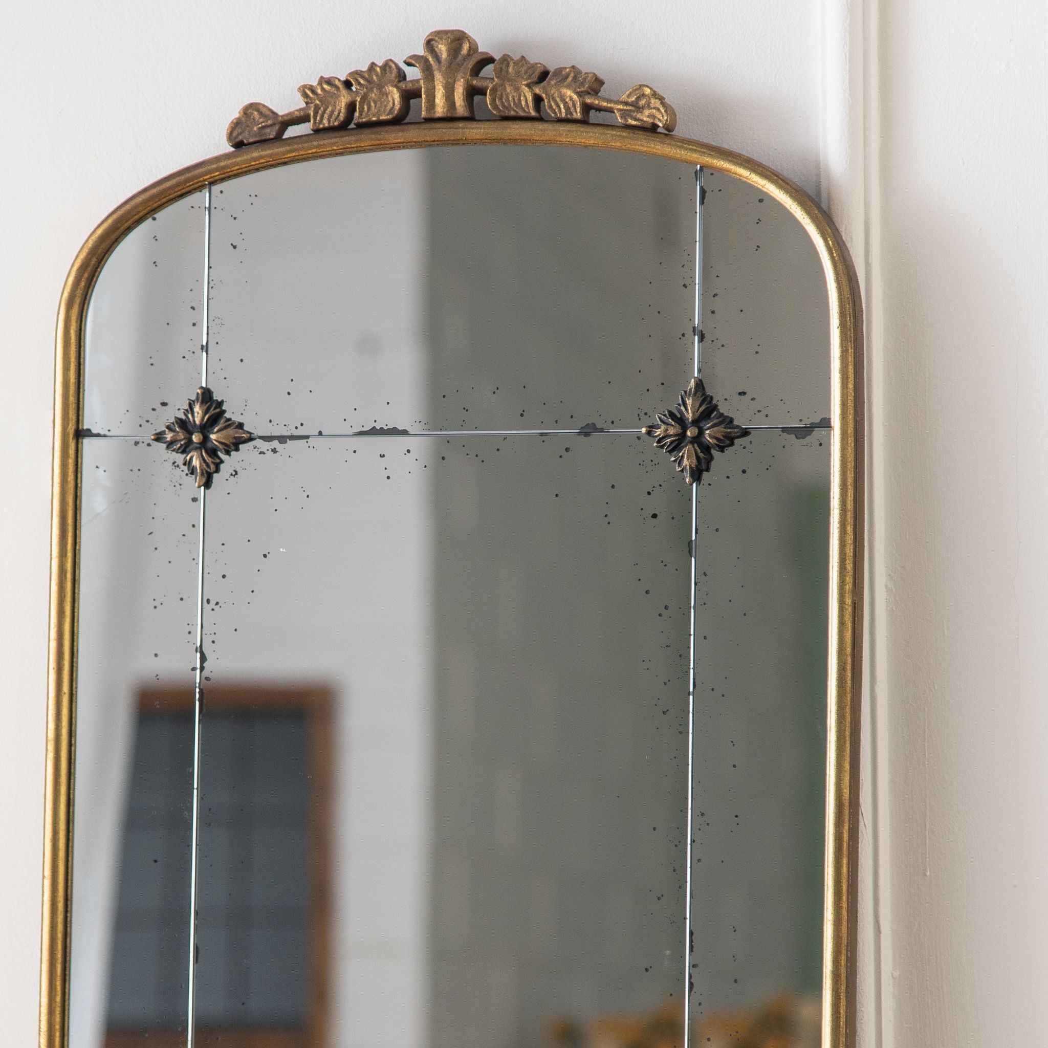Thea arched mirror foliate crest close up in aged gold