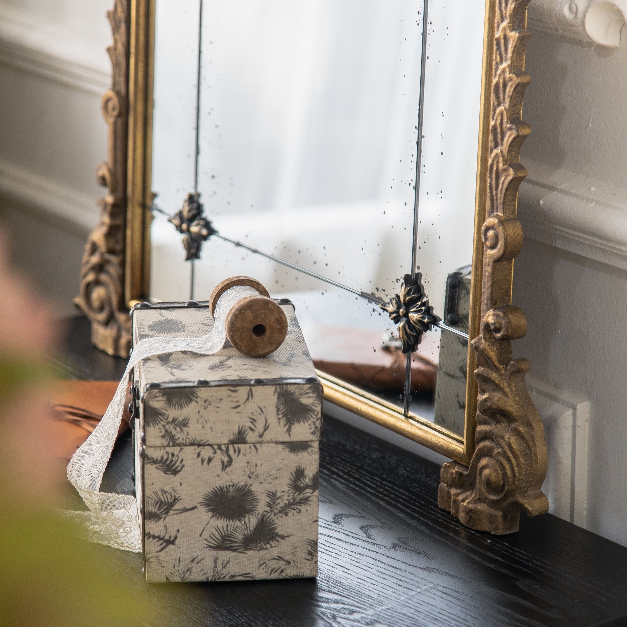 Thea mirror scrolled foot detail in aged gold