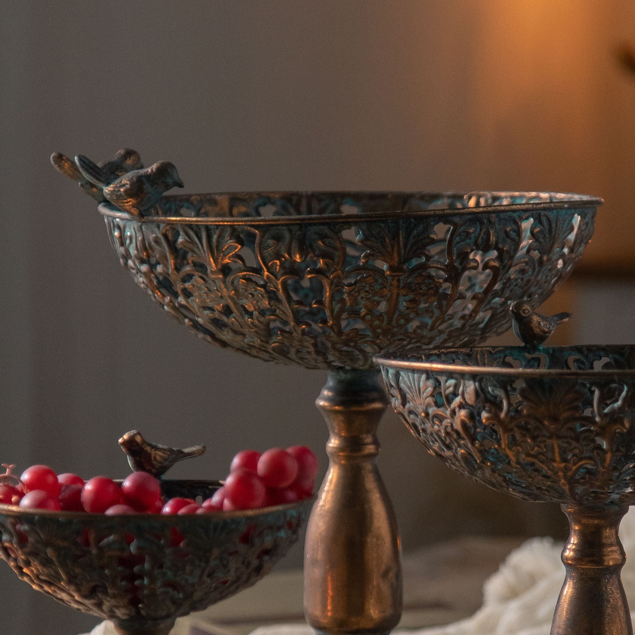 Close view of the pierced filigree bowl and bird detail on the Santo pedestal bowl