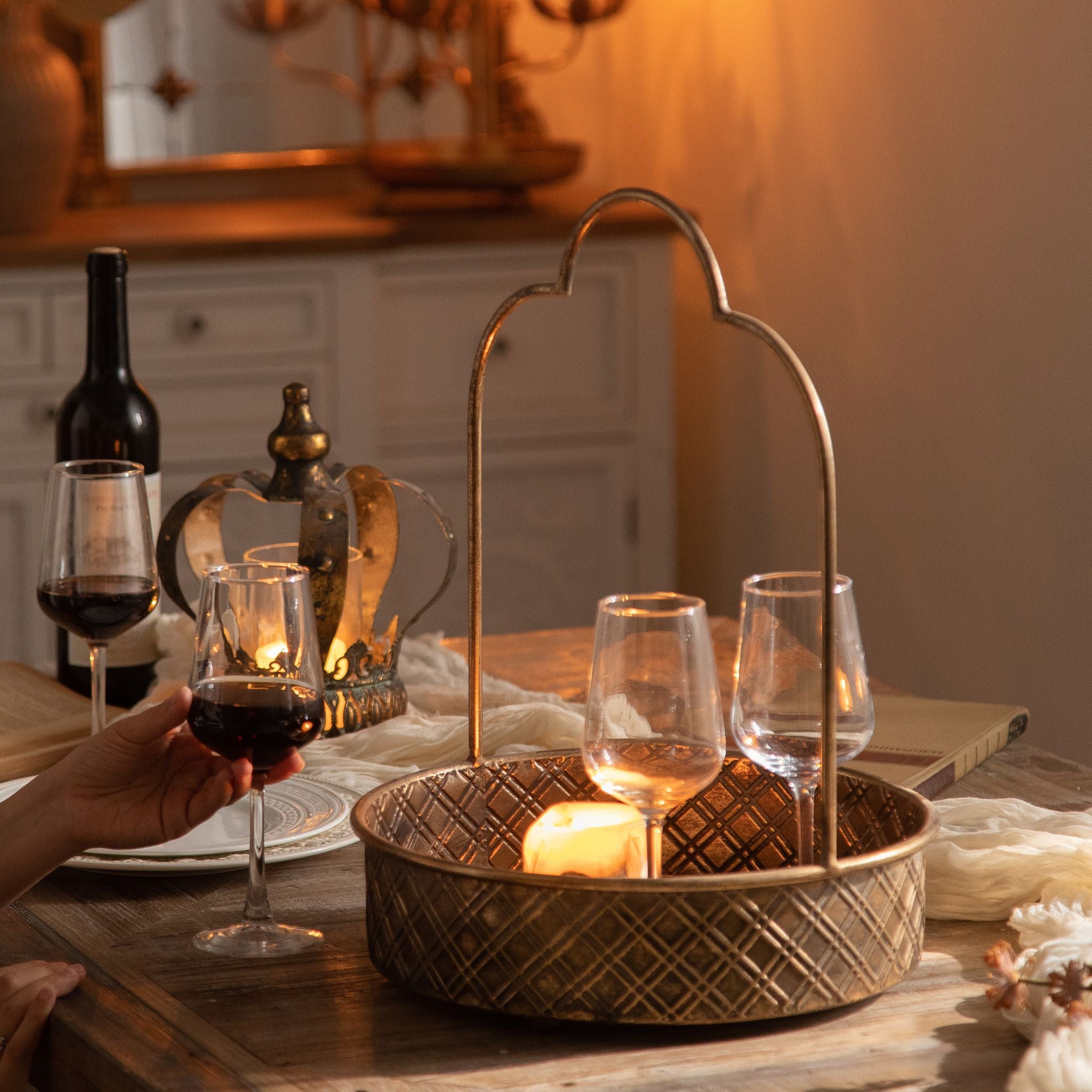 Remo round tray in antique gold with embossed lattice sides holding glasses and a candle