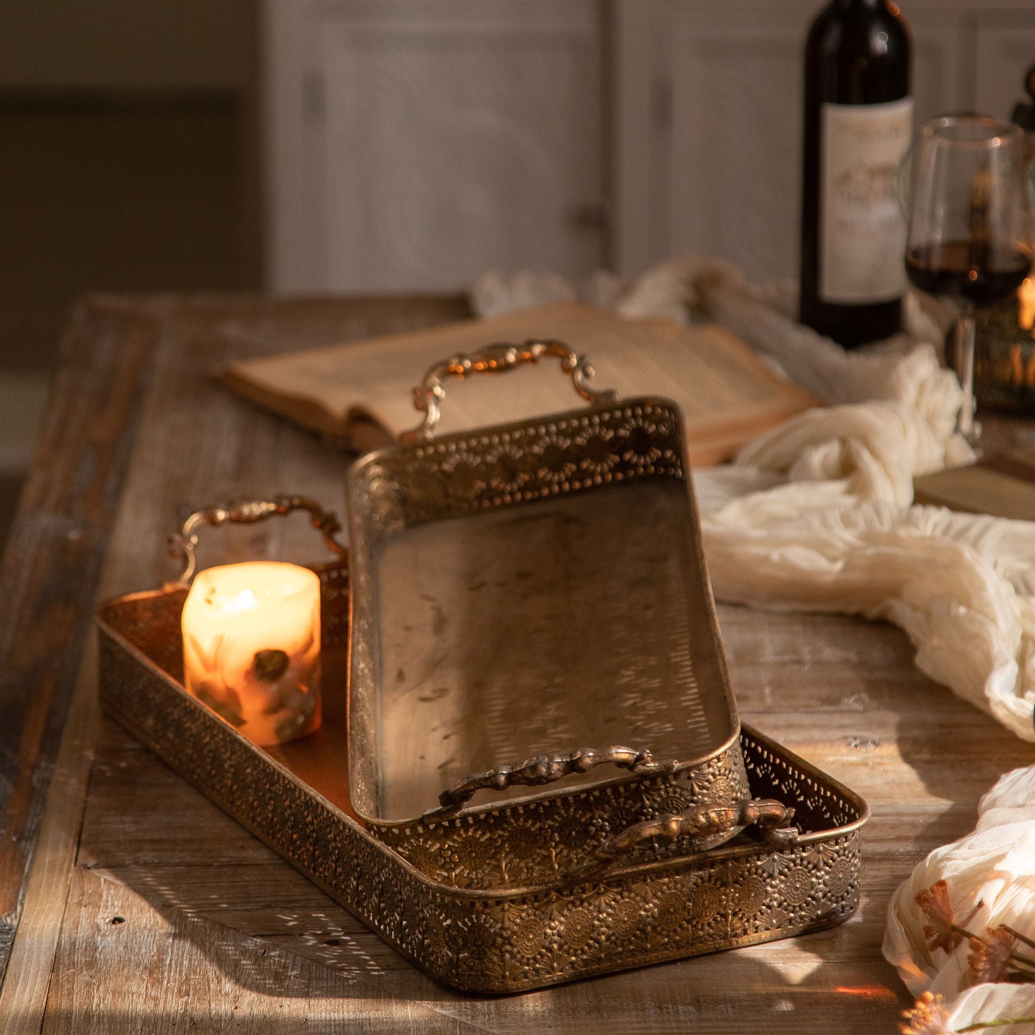 Ravello filigree tray in antique gold holding two wine glasses and a candle
