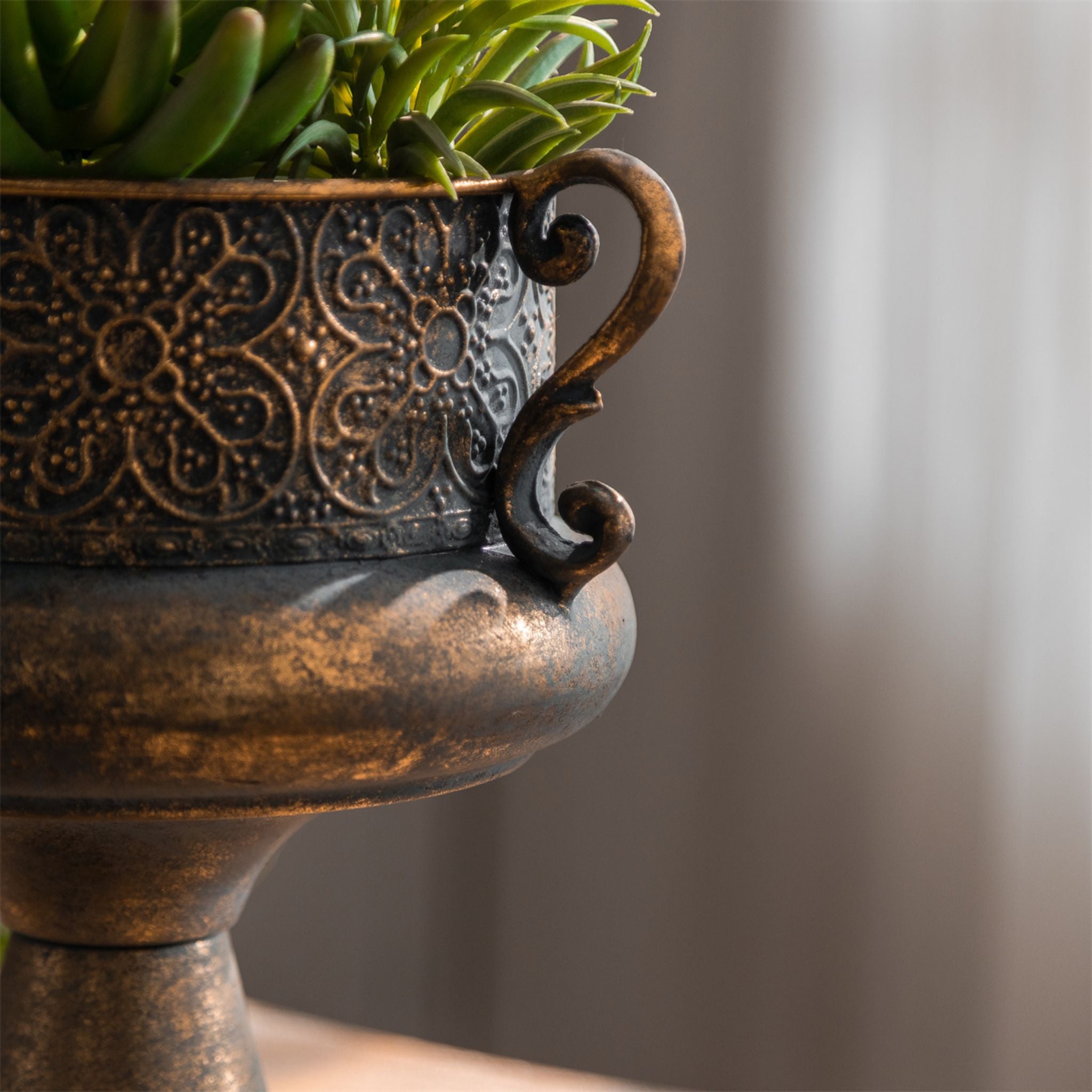 Amalfi urn planter filled with succulents on a timber table