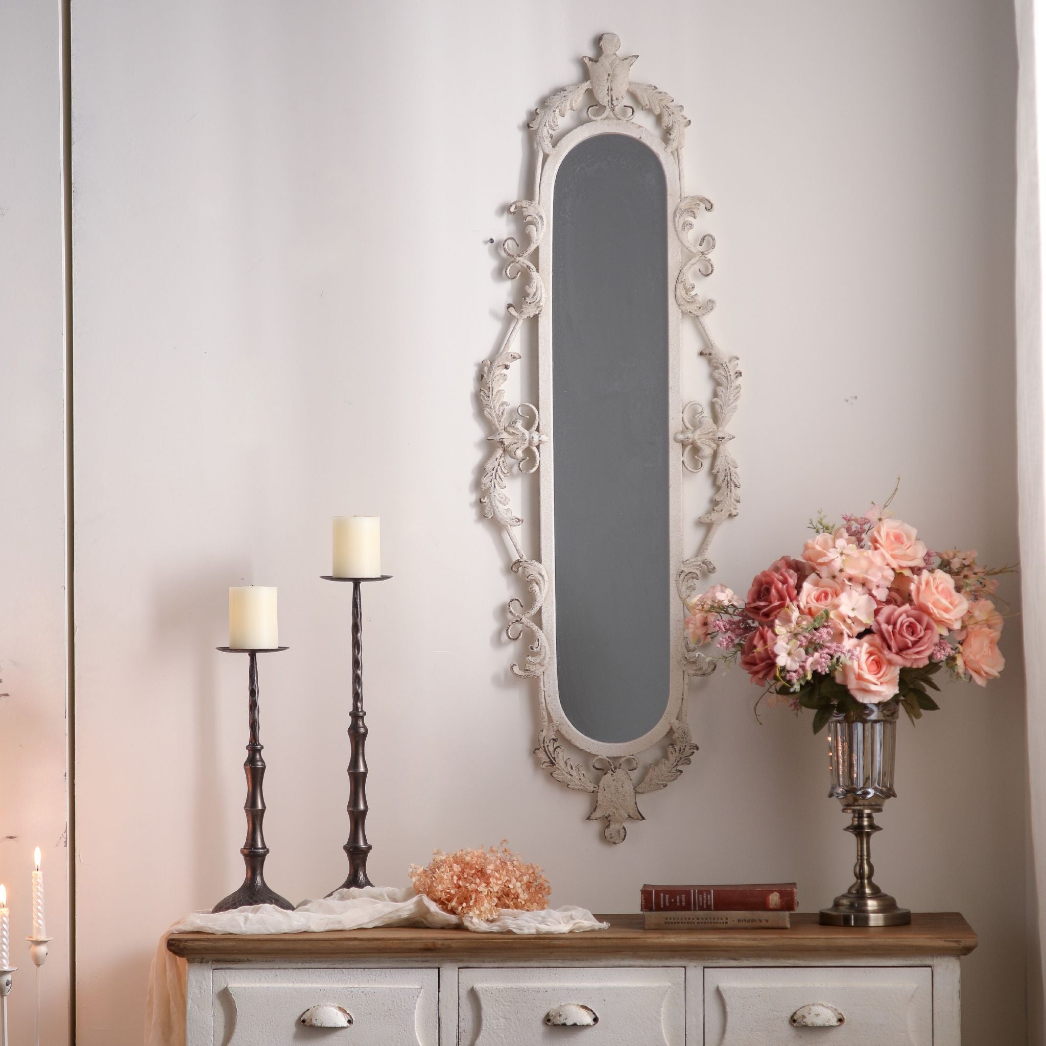Pilar tall oval wall mirror with ornate scroll frame in distressed white above a console