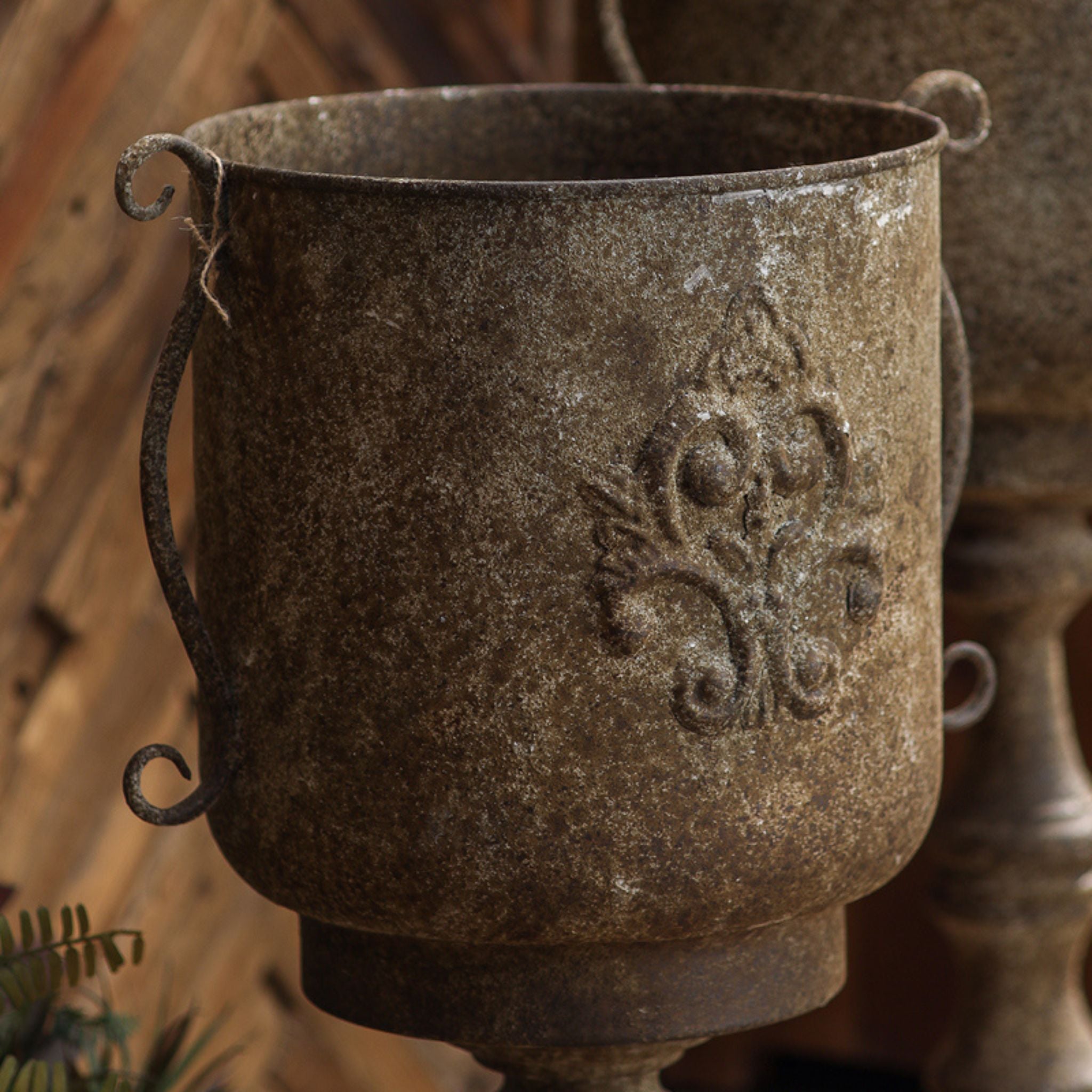 Close view of the raised fleur de lis crest and mottled finish on the Gloria urn