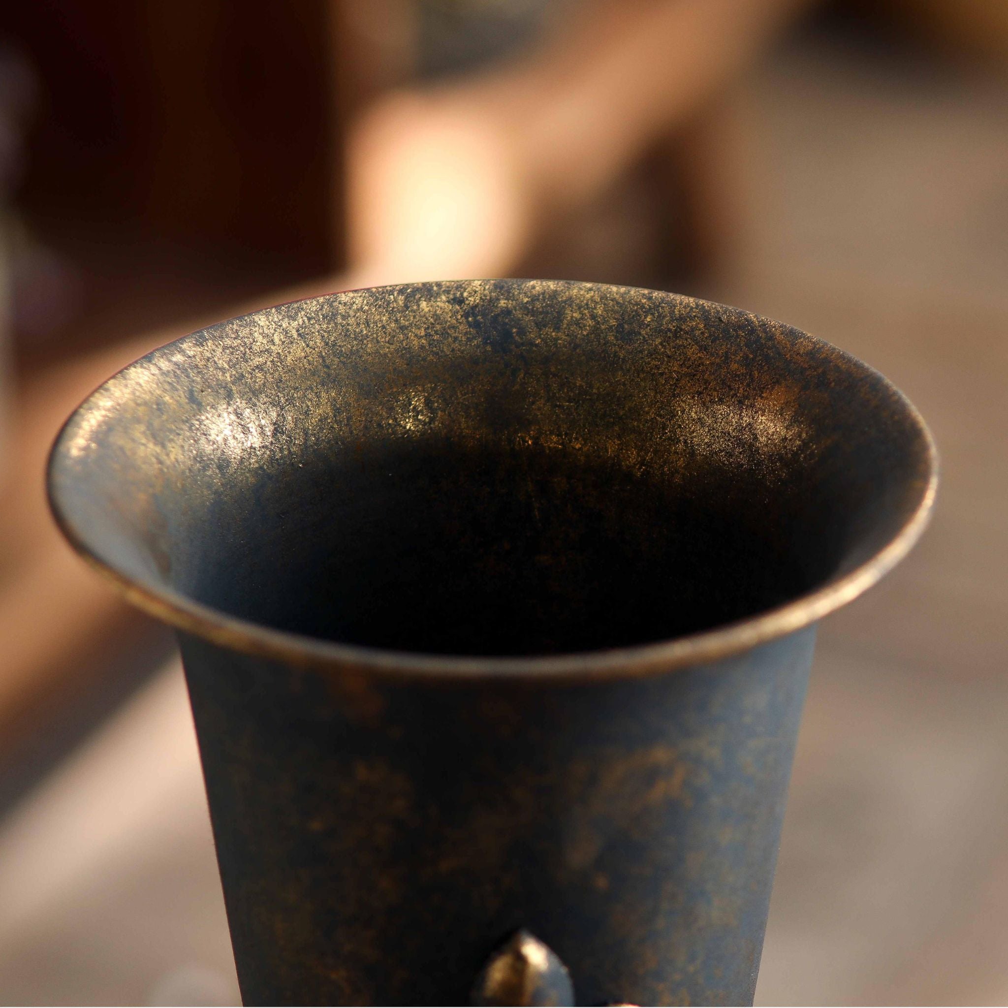 Close view of the raised fleur de lis emblem and gold tones on the Guido vase